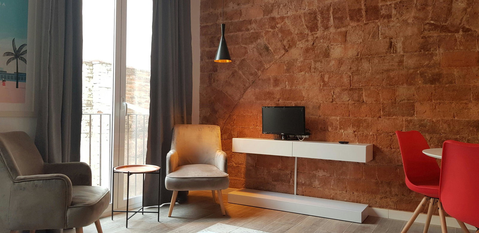 Exposed historic brickwork meets modern design in this sunlit living space. Relax in the cozy seating area before heading out to explore.