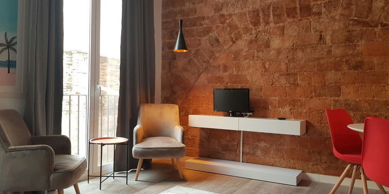 Exposed historic brickwork meets modern design in this sunlit living space. Relax in the cozy seating area before heading out to explore.