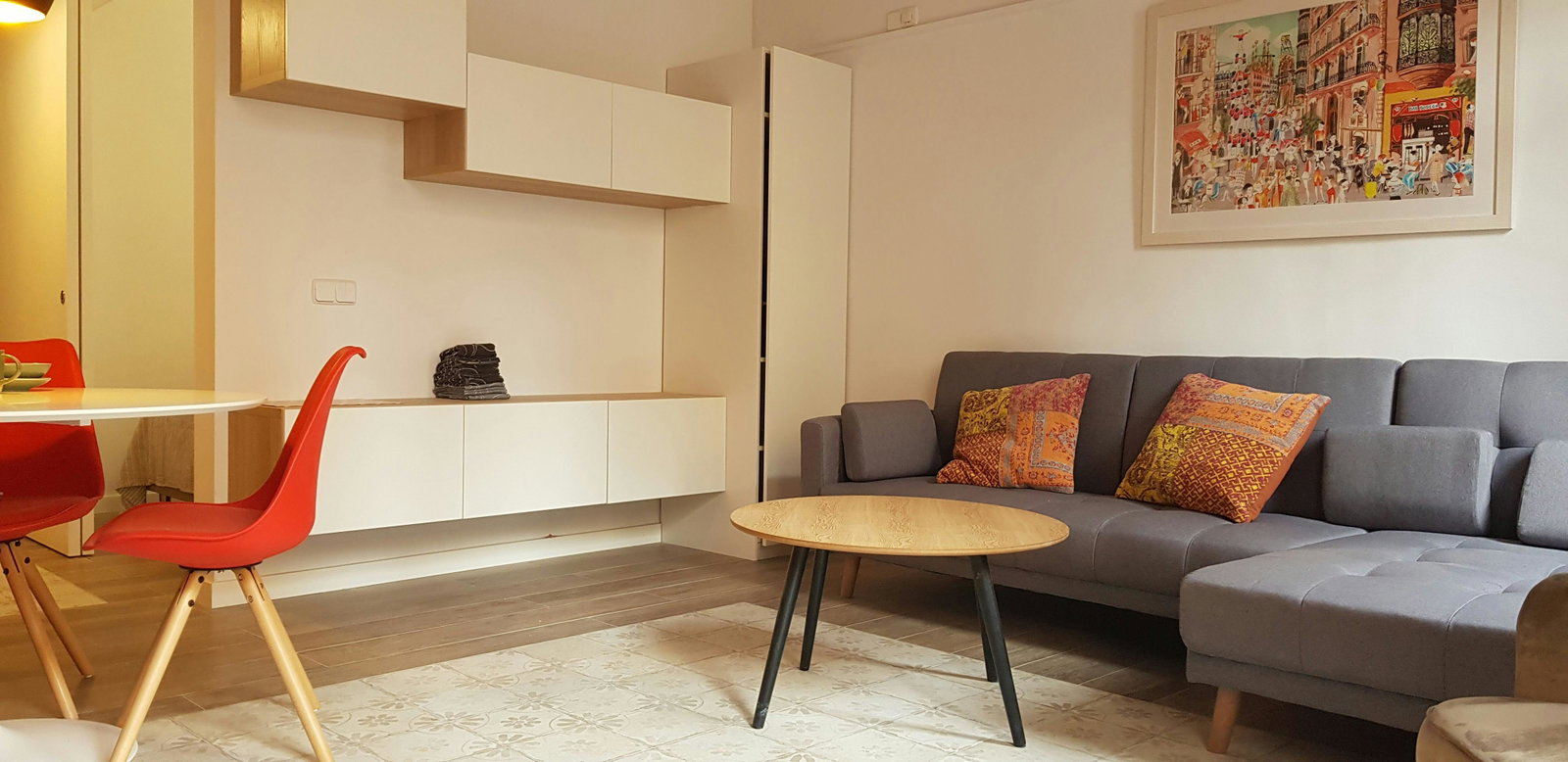 The living room is a bright and airy space with a large, comfortable grey sofa. In case of separate sleeping arrangements, the sofa can be converted into a sofa bed (upon prior request).