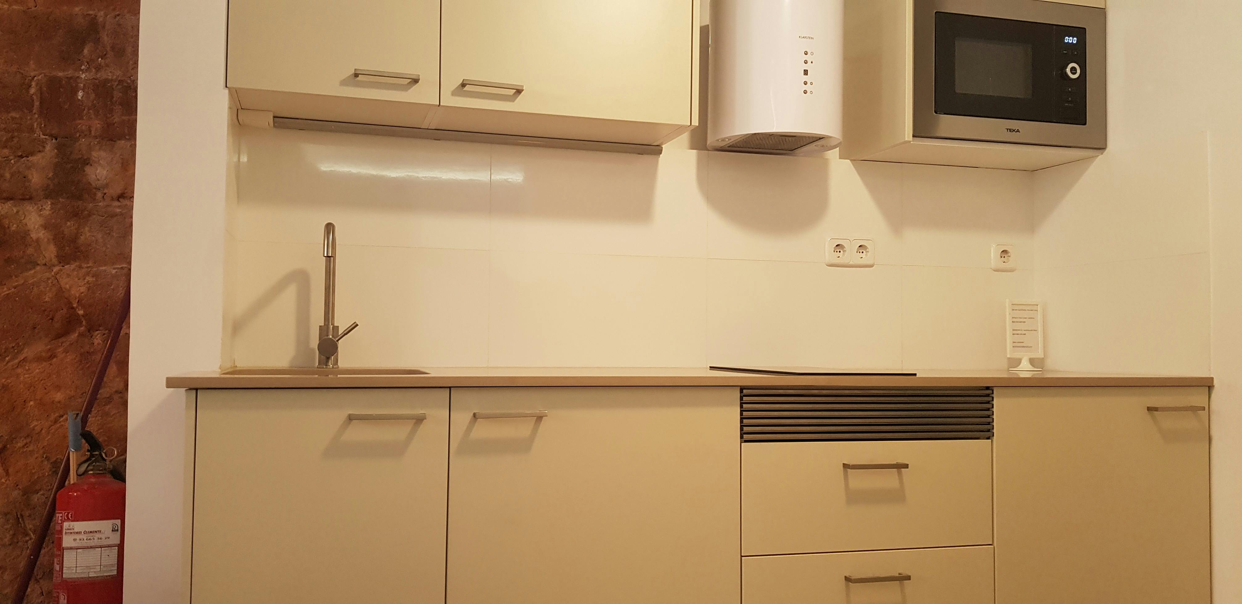 The open kitchen boasts modern appliances and ample storage space, including a microwave, a toaster, and a coffee maker. The sleek countertop offers a practical workspace for preparing meals.