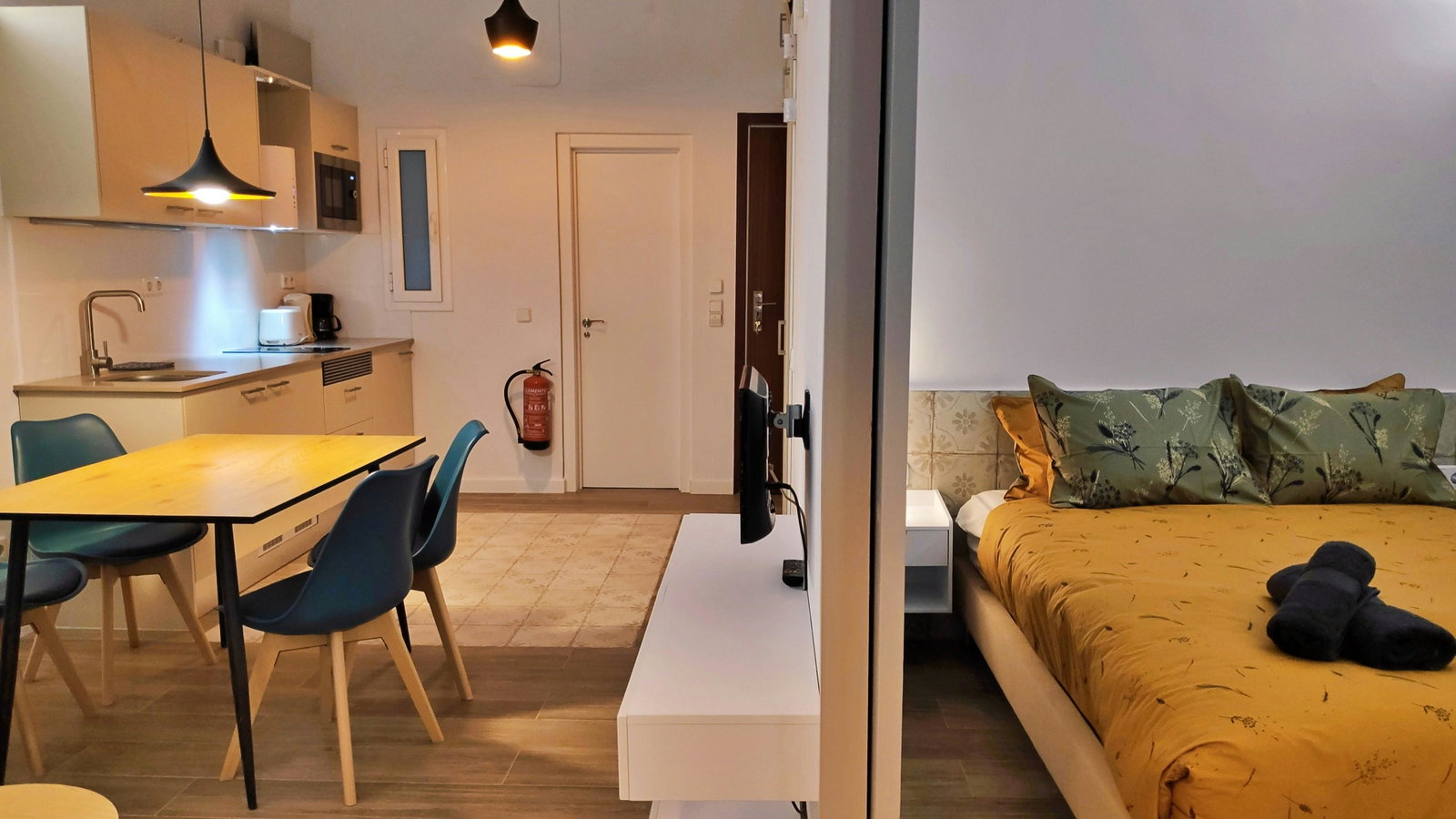 This modern apartment features an open-plan layout with a well-defined sleeping area and a combined kitchen and dining space.