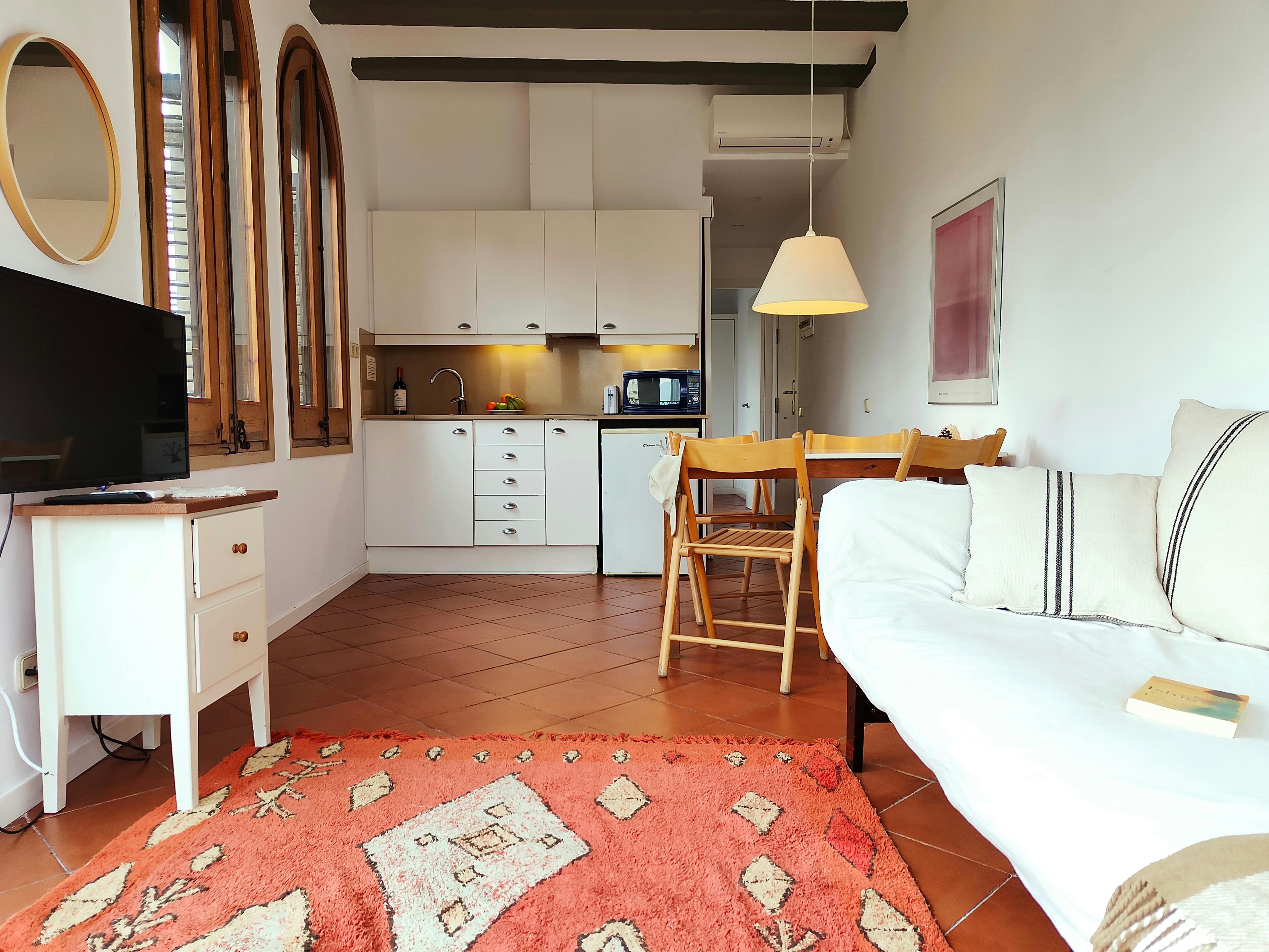 Living room with a sofa, dining table and an auxiliary table with TV. Open kitchen equipped with all its necessary tools, such as: a microwave, toaster, coffee maker.