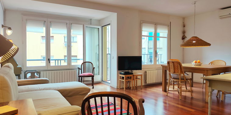 Relax in this bright, open-plan living space featuring warm hardwood floors and access to a sunny terrace.