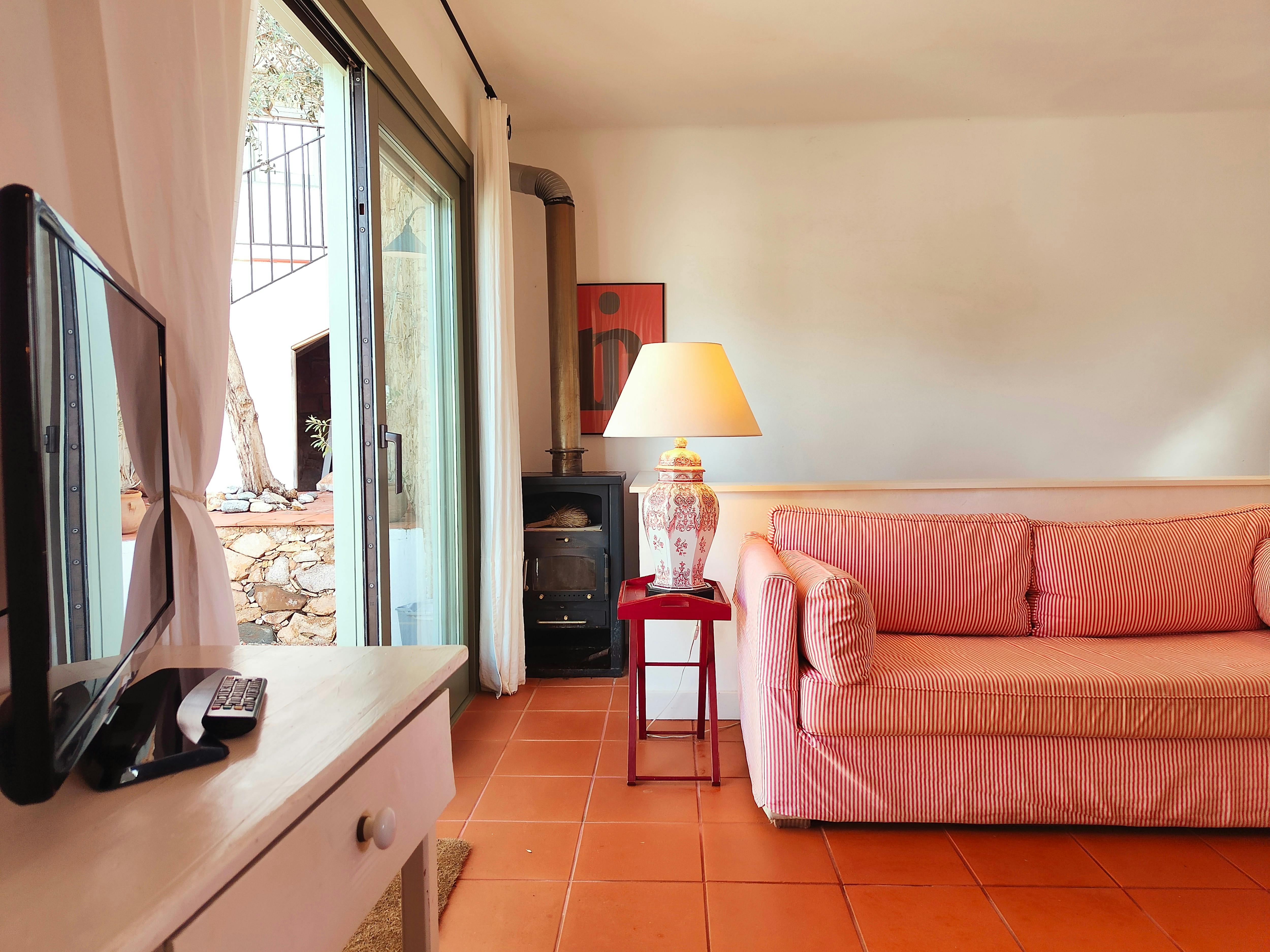 The living room is a bright and airy space with a comfortable red and white striped sofa.