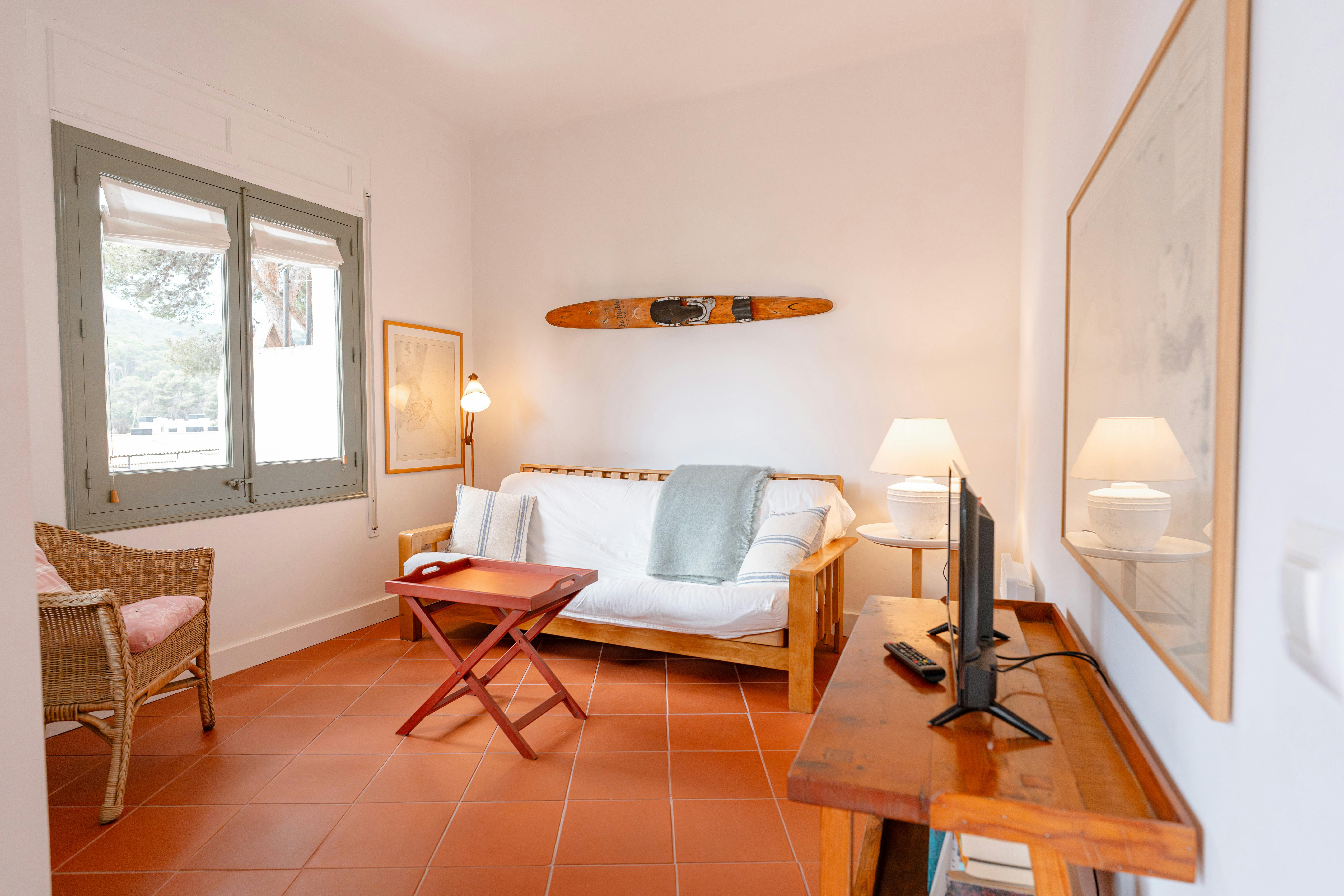 Spacious living area with a comfy sofa bed, perfect for kids or teens, all bathed in natural light for a warm, inviting atmosphere.