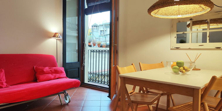 4th floor. The room is bathed in natural light from a set of French doors that open onto a small balcony overlooking a quiet courtyard.