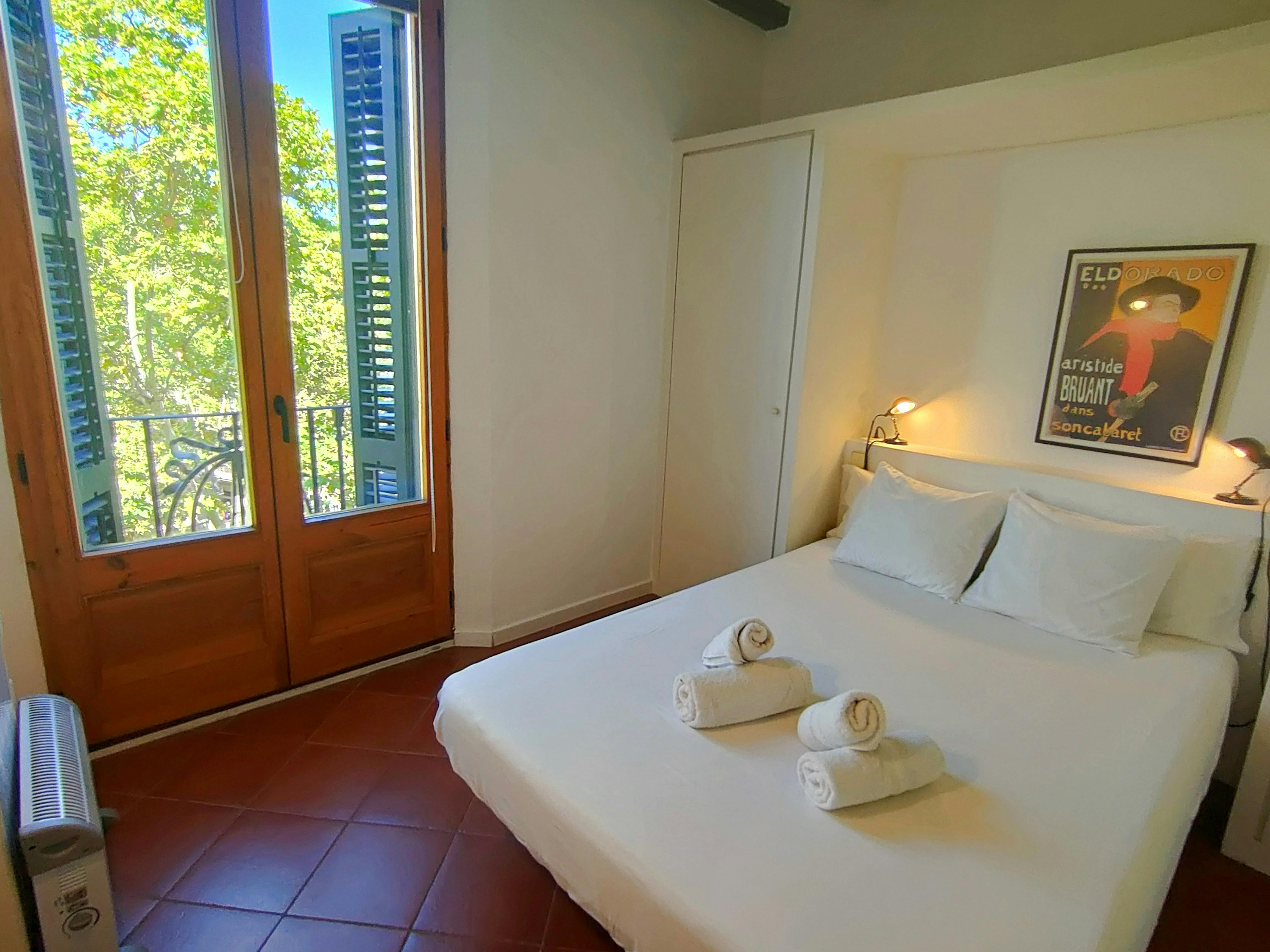 Wake up to natural light and iconic views of La Rambla from your spacious double bedroom with a classic French balcony.