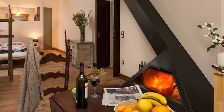 Relájese junto al cálido resplandor de la chimenea en este acogedor y rústico espacio de planta abierta. Un ambiente perfecto para una escapada tranquila.