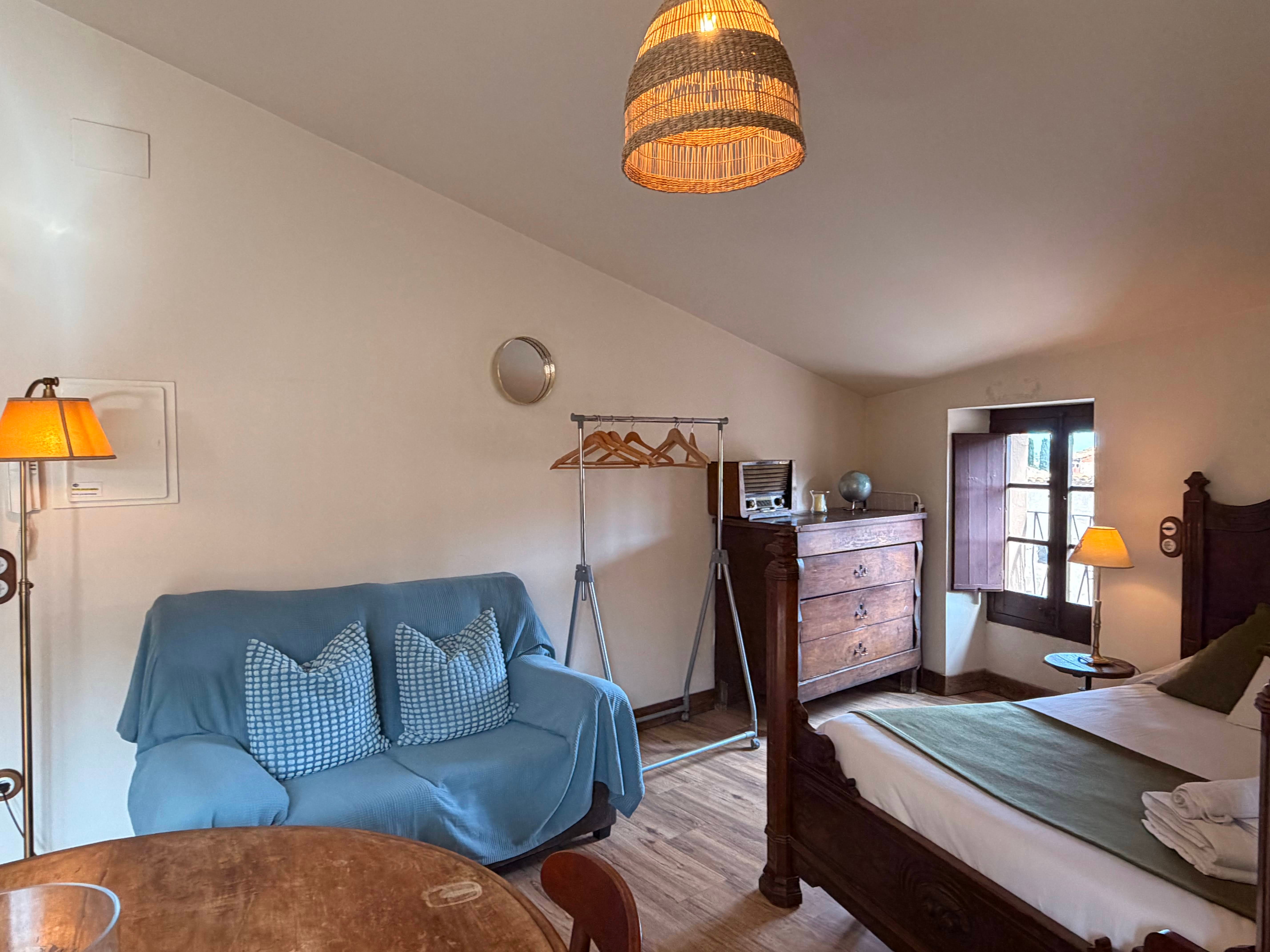 Unwind in this charming room where rustic wooden furniture and warm lighting create an intimate and cozy atmosphere for a truly restful stay.