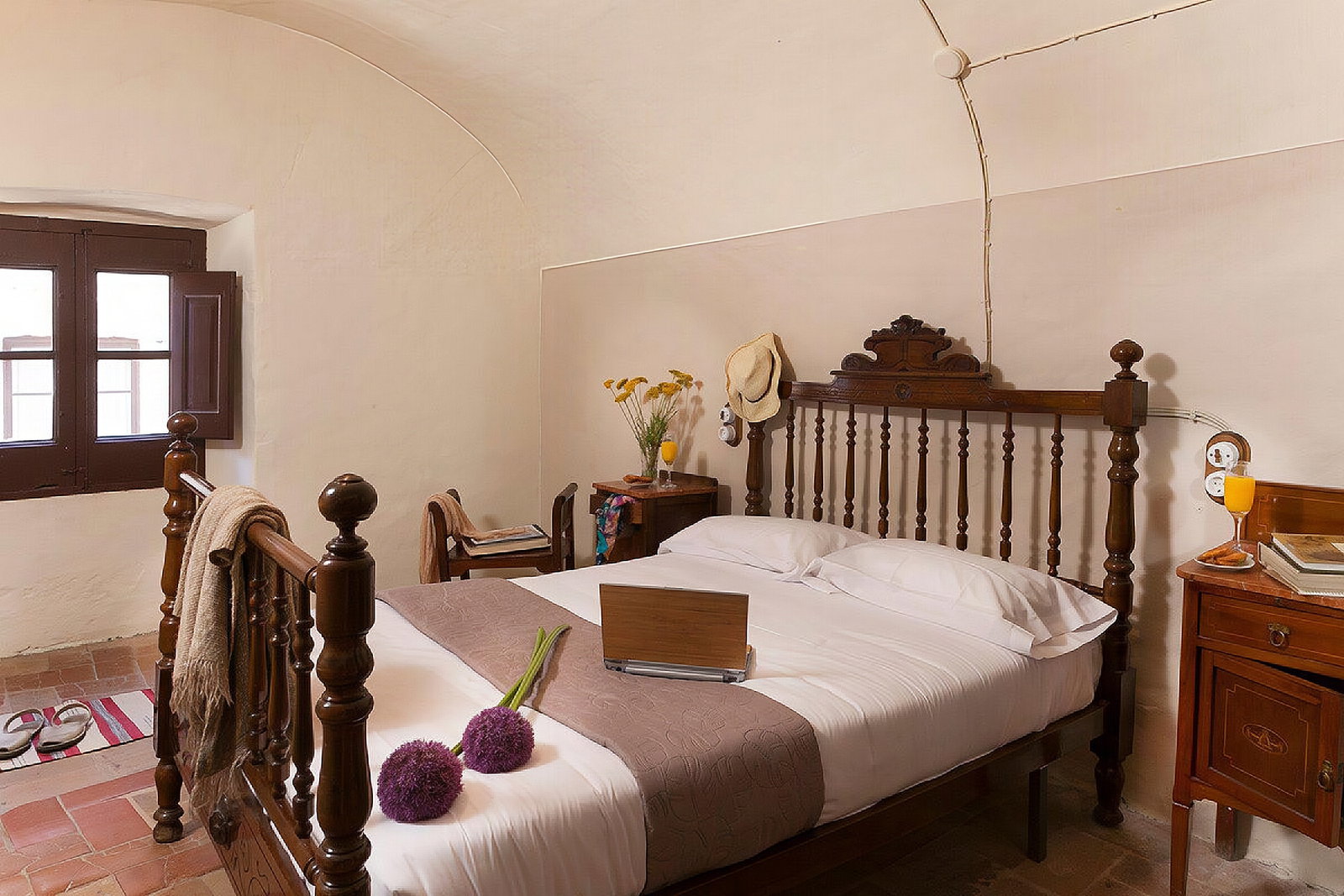 Unwind in the authentic charm of this spacious bedroom, featuring a classic wooden bed and a traditional vaulted ceiling.