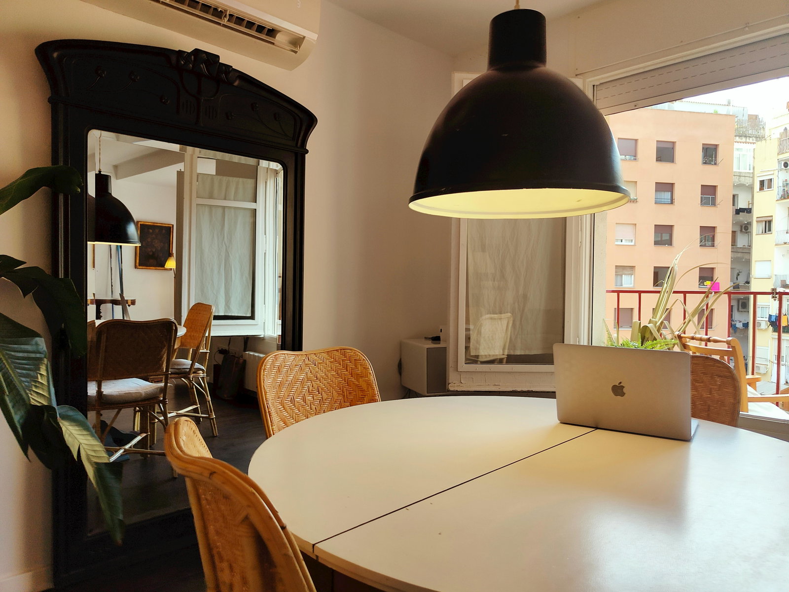 The spacious dining area features a round white table. Natural light that floods in from the large window. The sleek modern design of the furniture adds a touch of sophistication to the room.