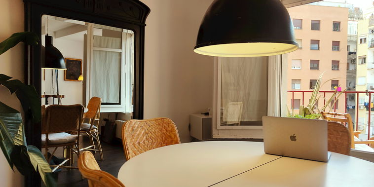 The spacious dining area features a round white table. Natural light that floods in from the large window. The sleek modern design of the furniture adds a touch of sophistication to the room.