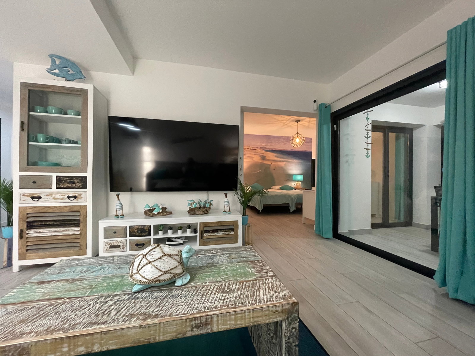 Le salon lumineux, décoré sur le thème de la mer, s'ouvre sur une chambre apaisante et une terrasse. Un grand écran invite à la détente.