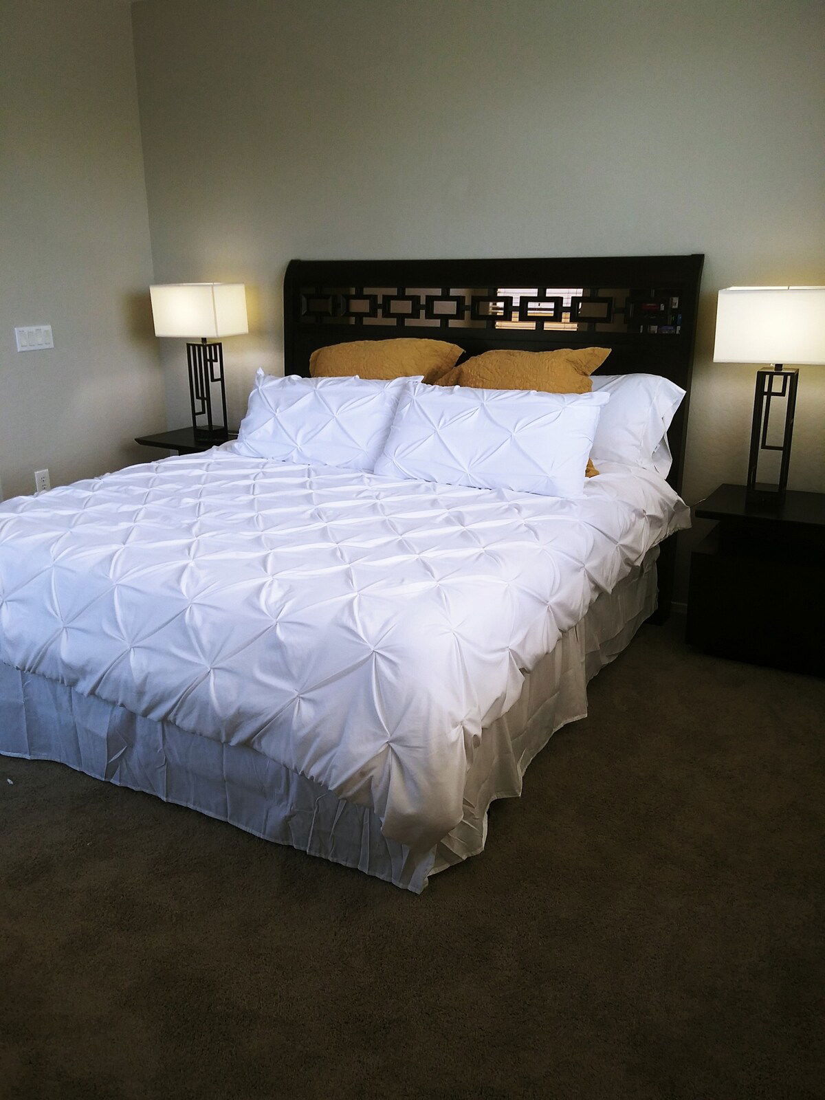 Luxury linen and a king sized bed in the Master bedroom. Dark colored furniture with geometric patterns add a modern touch of elegance to the spacious master bedroom.  43" wall mounted television, ceiling fan and 110 AC outlet on the nightstand lamps