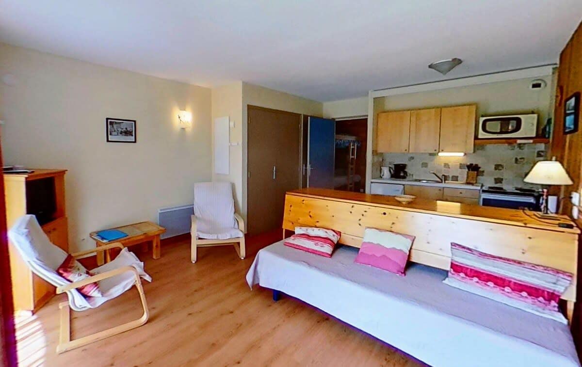 The exterior of the building features a charming wooden facade, with a snow-covered roof and a balcony overlooking the snowy landscape. The building's architecture blends seamlessly with the alpine surroundings, offering a picturesque setting for a peaceful and relaxing getaway.