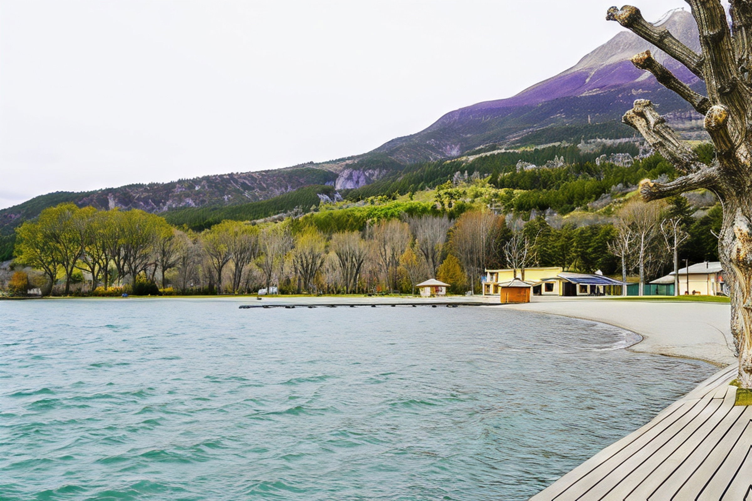 A tranquil view of Lake Sainte Croix, with a wooden walkway leading out towards the water. The lake is surrounded by lush greenery, including a picturesque mountain range in the background. The lake is calm and inviting, with a gentle breeze creating small ripples on the surface.  The image provides a glimpse of the serene natural beauty that awaits guests at Casa-Isabelle.