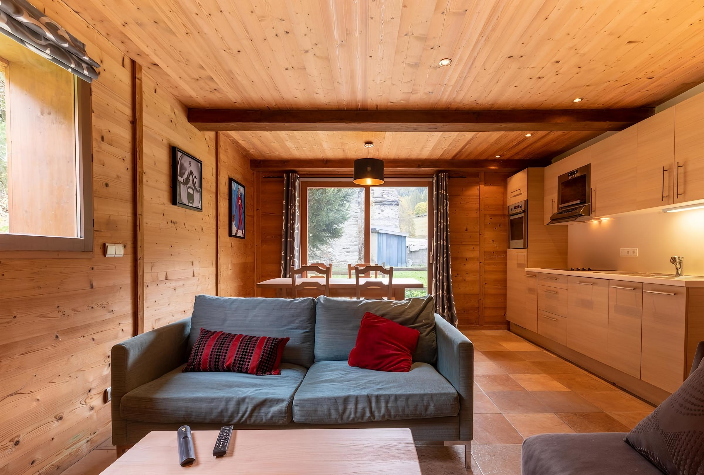 This cozy bedroom features two single beds with a festive patterned duvet, perfect for a relaxing night's sleep after a day on the slopes. The room is beautifully decorated with wood paneling and warm lighting, creating a warm and inviting ambiance.