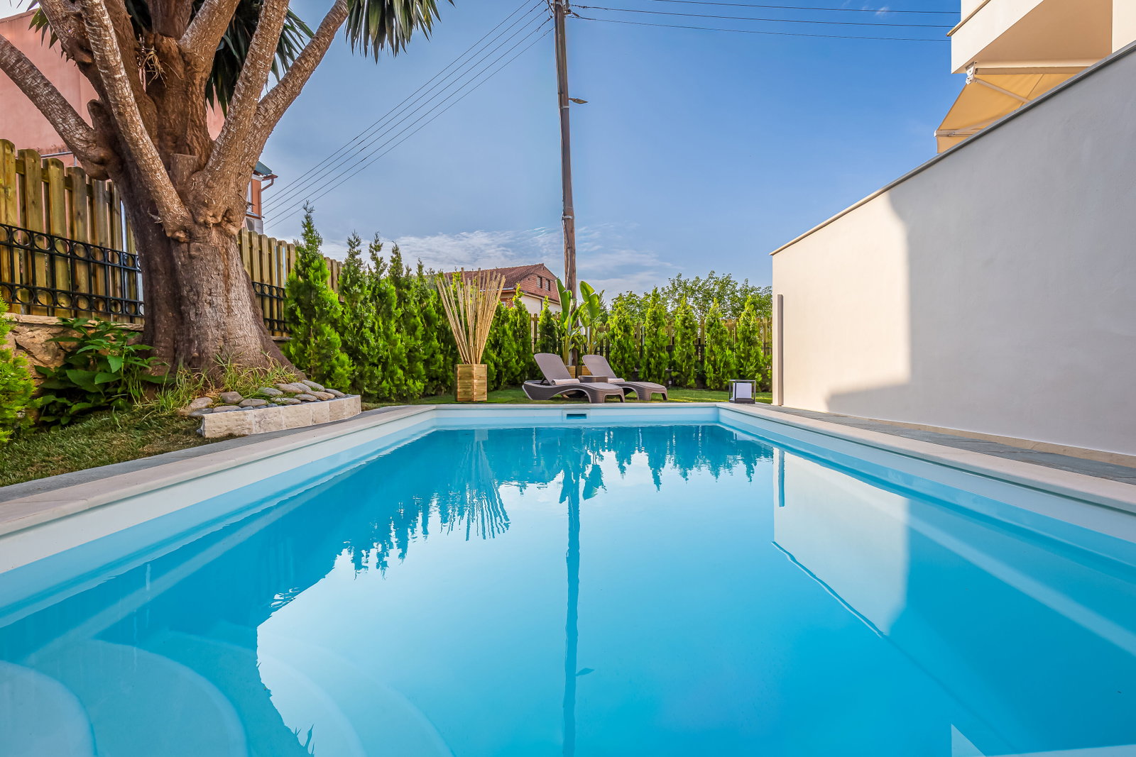 "Indulge in outdoor luxury in our private garden sanctuary, boasting a refreshing pool, heated jacuzzi, and verdant surroundings."