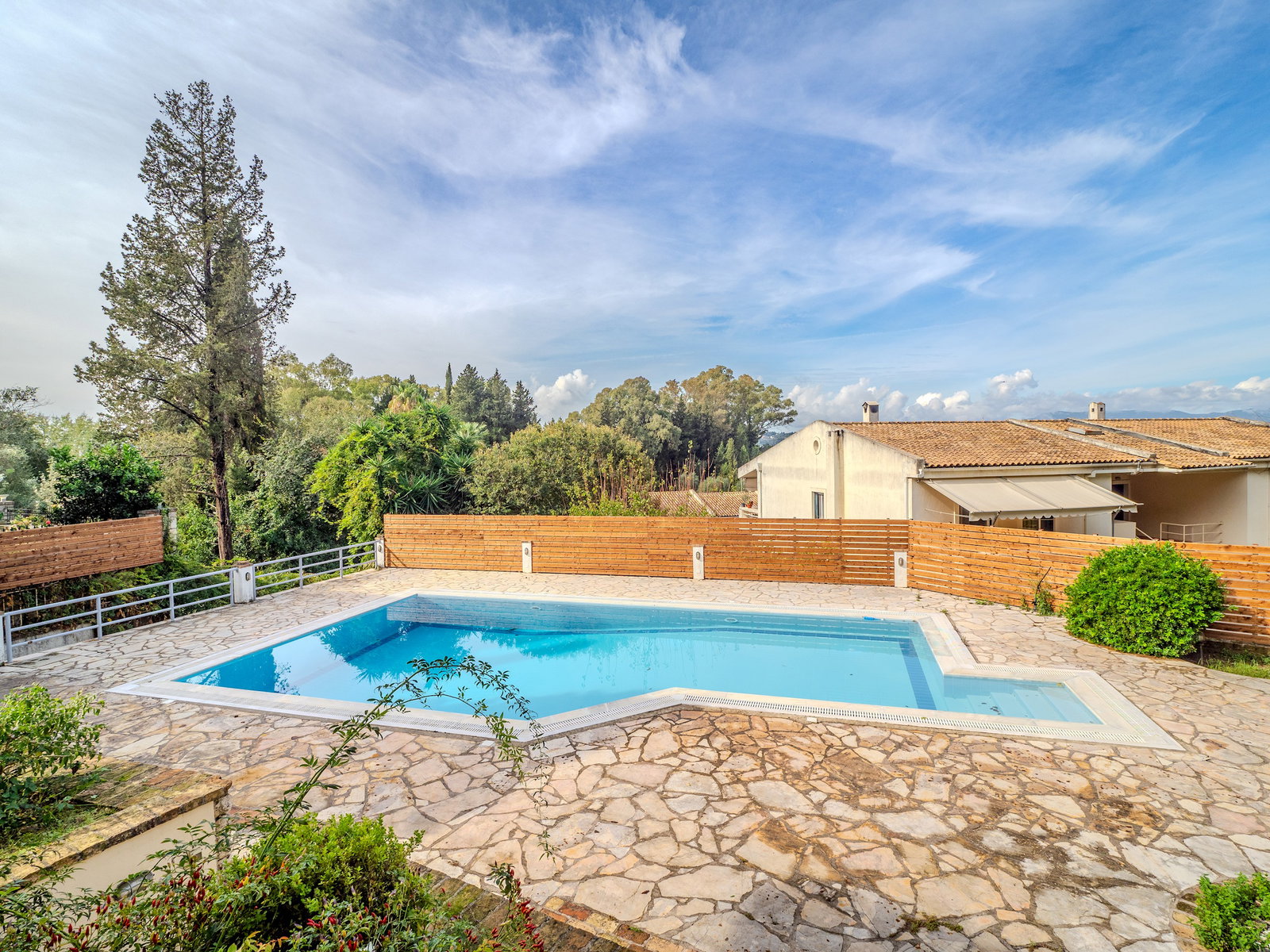 "Savor the tranquility of our outdoor oasis, where the soothing sounds of nature accompany every dip in the pool."