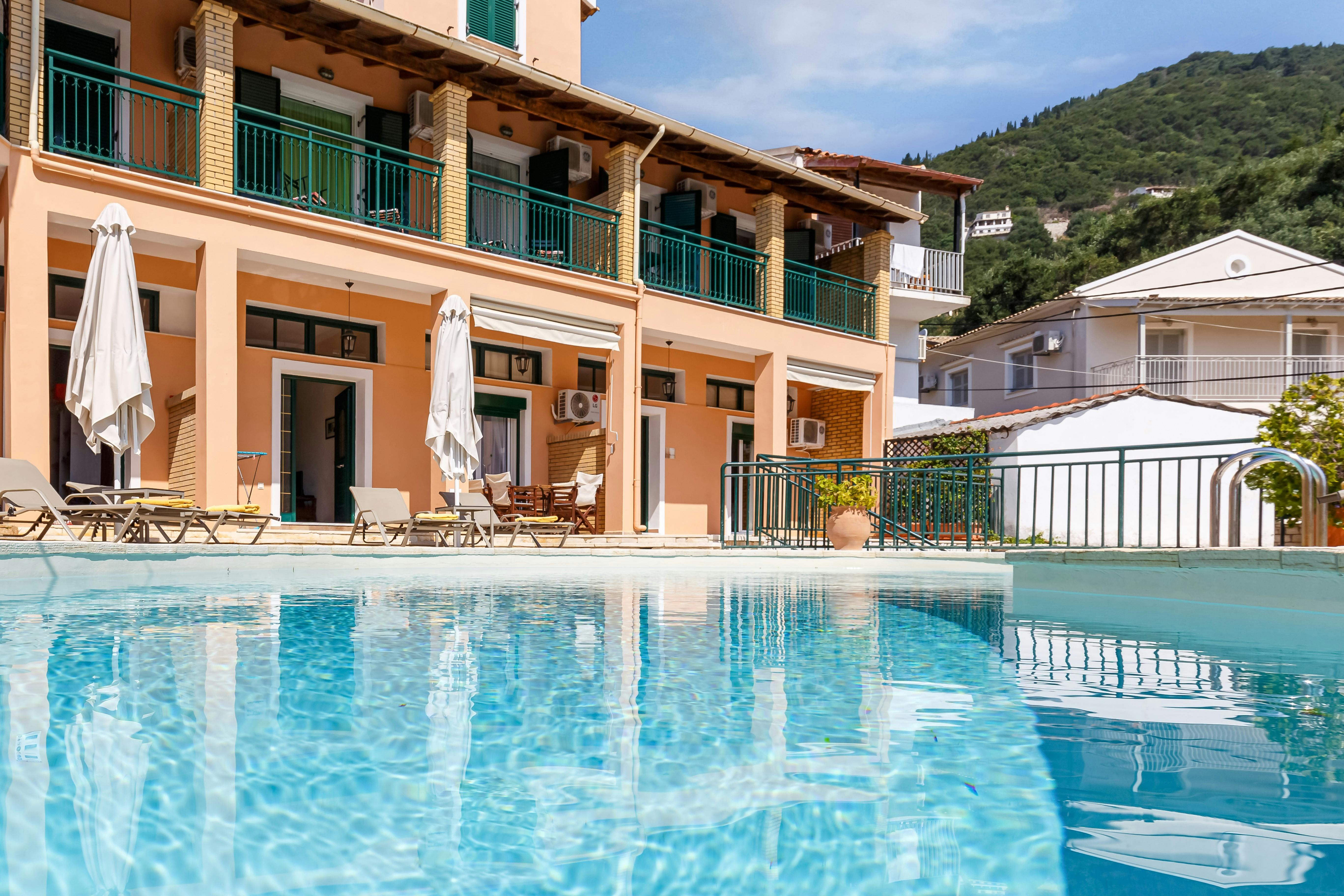 "Villas Delphine and Nikos By Tsiolis Family next to each other. Relax by the large shared swimming pool with sunbeds and umbrellas, perfect for unwinding under the Corfiot sun."