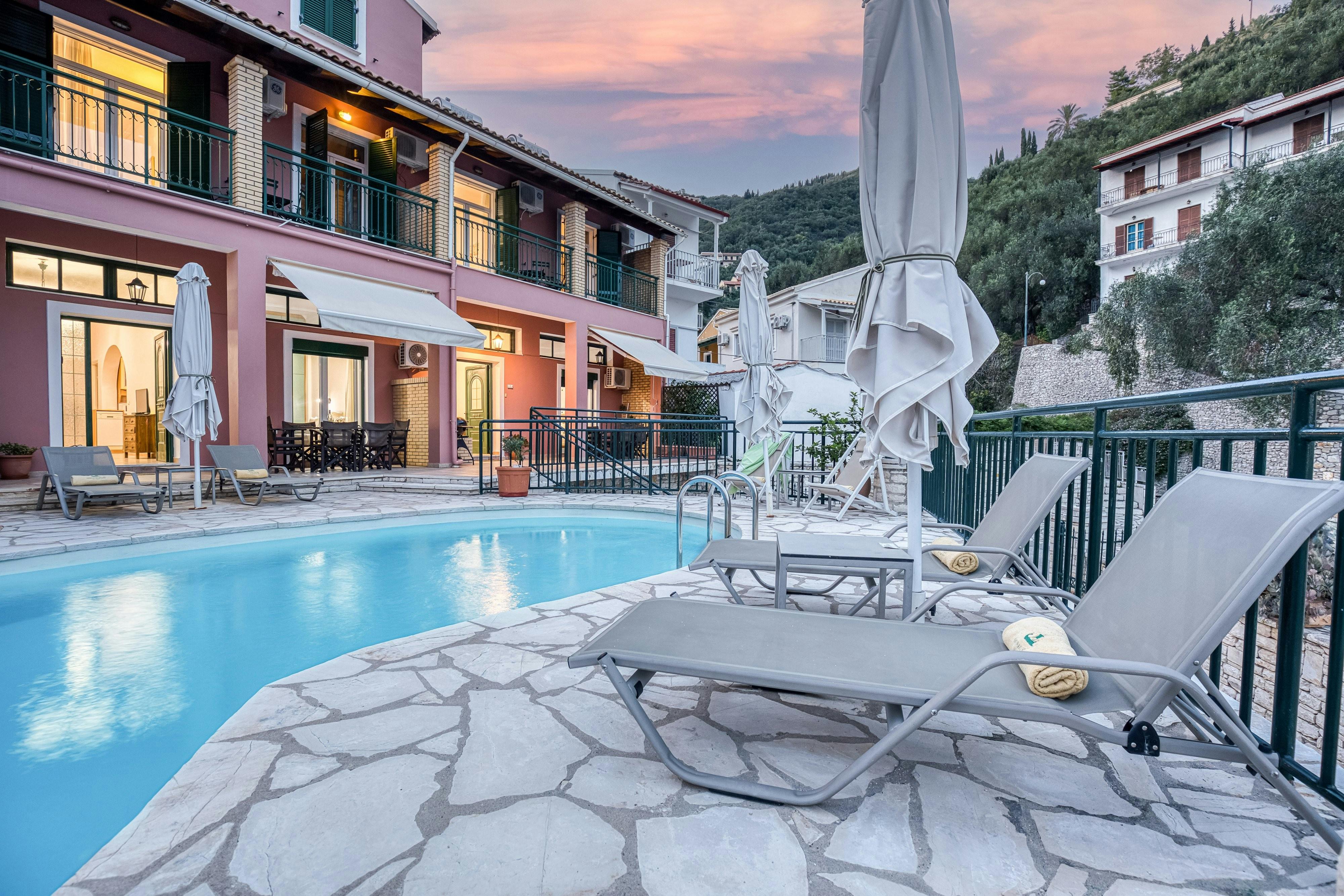 "The villas common pool area is beautifully lit at sunset, ideal for evening relaxation."
