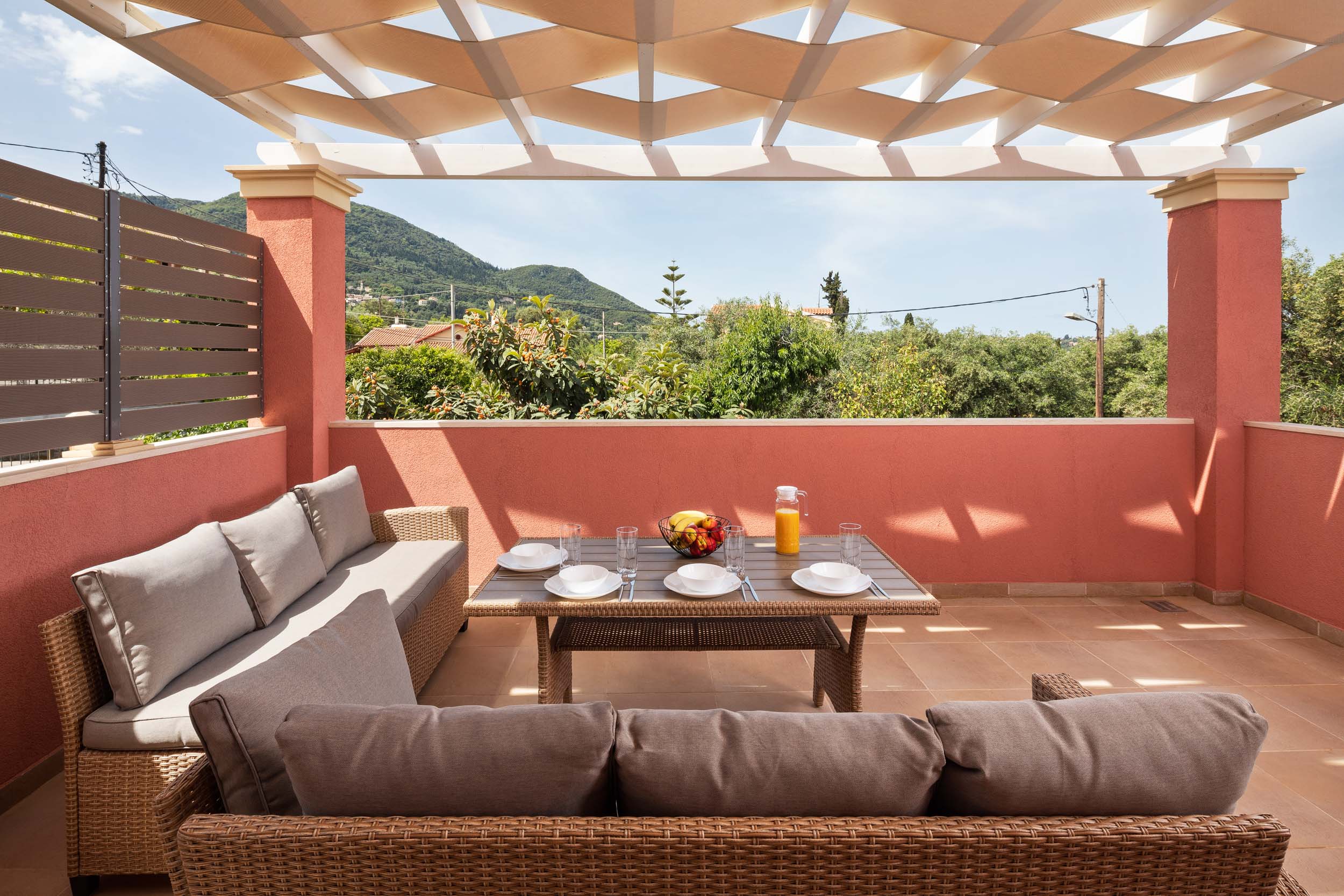 "Experience serene relaxation at Achilleio Alexandros Cottage, where comfort meets picturesque mountain views on your private sun-dappled terrace."