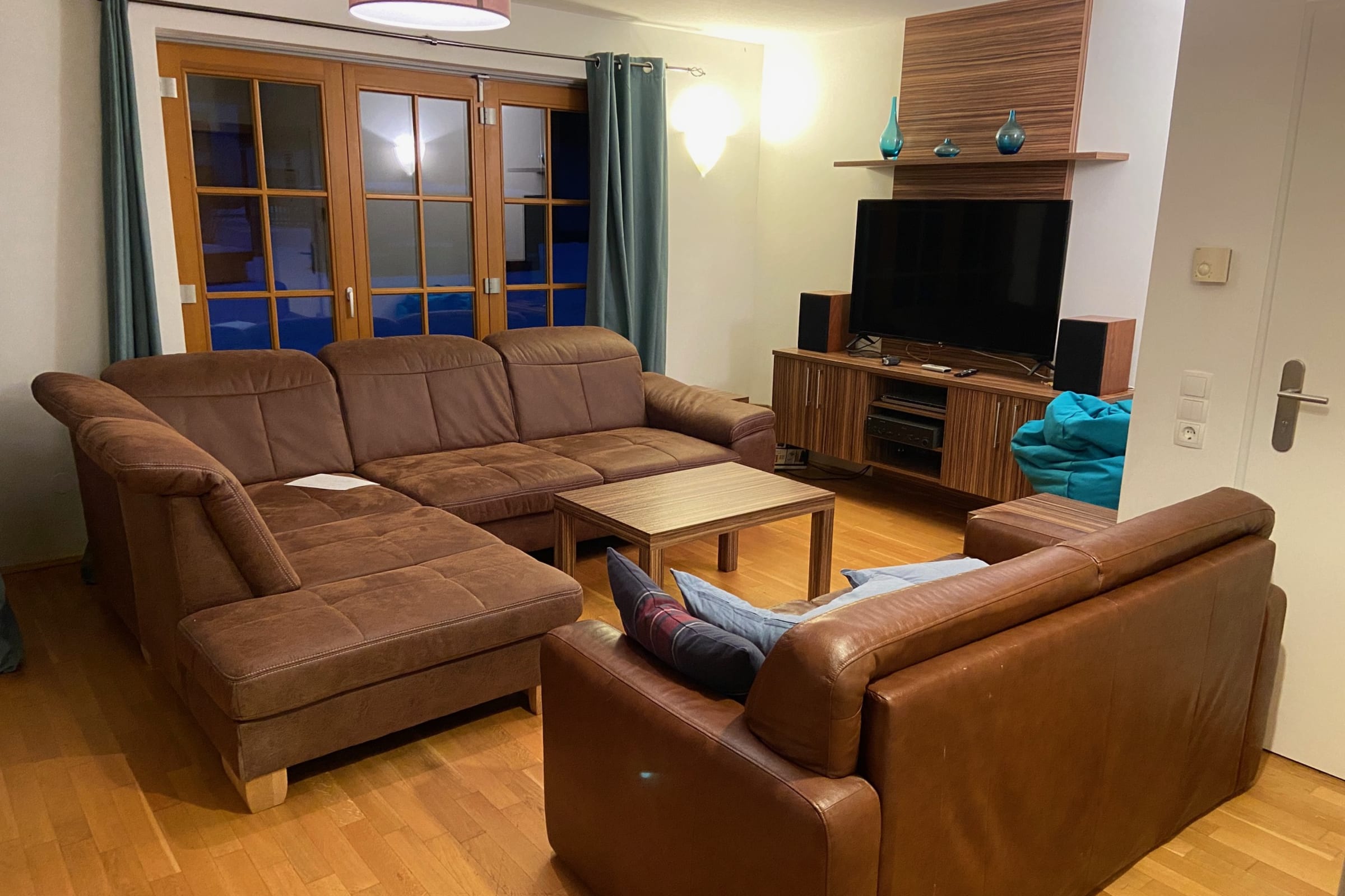 Rich wood floors and a plush leather sectional set the stage for relaxation in this stylish apartment. Modern amenities, including a large-screen TV and access to a spa, ensure a comfortable and entertaining stay for families or groups.