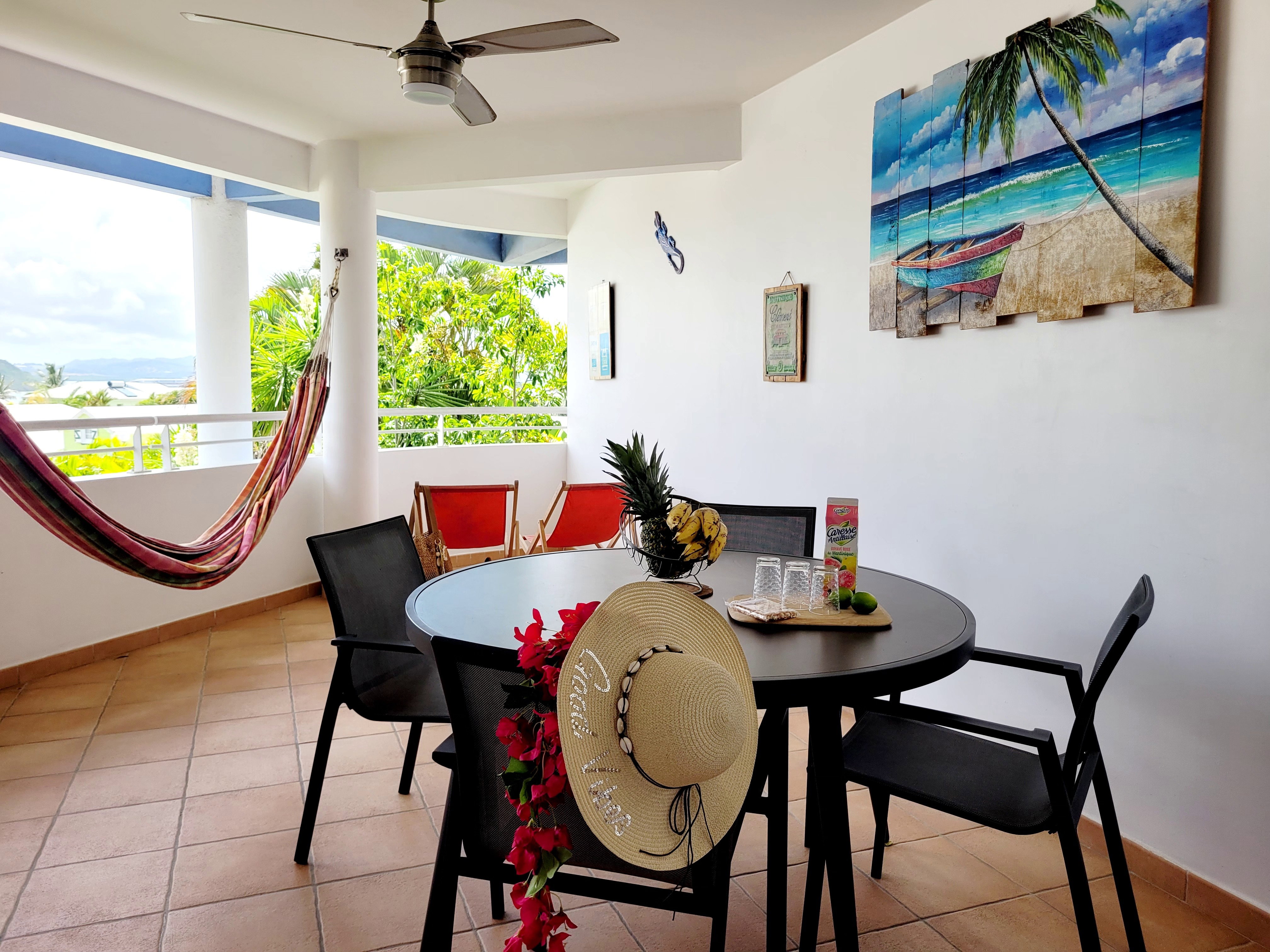 Grand balcon ventilé (plafond) avec hamac & transats pour chiller. Table + 4 chaises : le lieu idéal pour vos repas face à la vue magnifique sur les îlets des Trois-Îlets. Un vrai coin de paradis pour vos vacances !