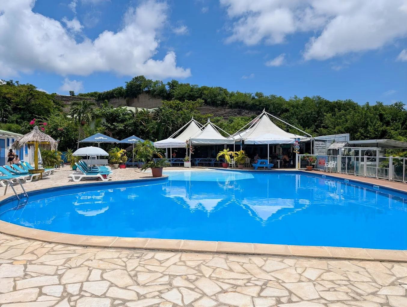 Grande piscine extérieure de la résidence, accessible en toute liberté et gratuitement par les voyageurs du Ti Colibri. Un véritable havre de paix pour vous détendre !