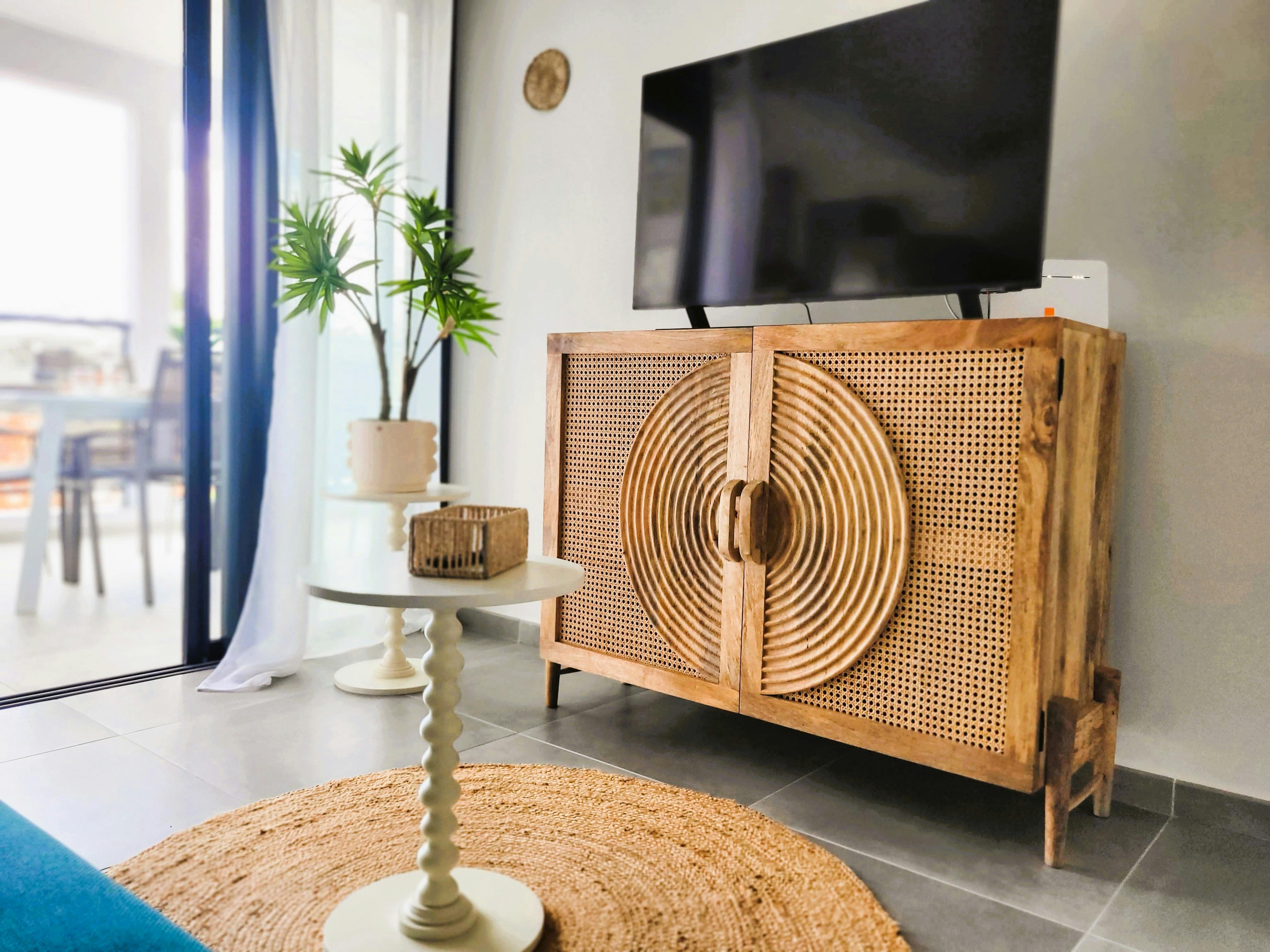 Salon lumineux avec canapé convertible, idéal pour une personne. TV connectée, espace ouvert sur la cuisine et accès direct au balcon pour profiter de l’extérieur.