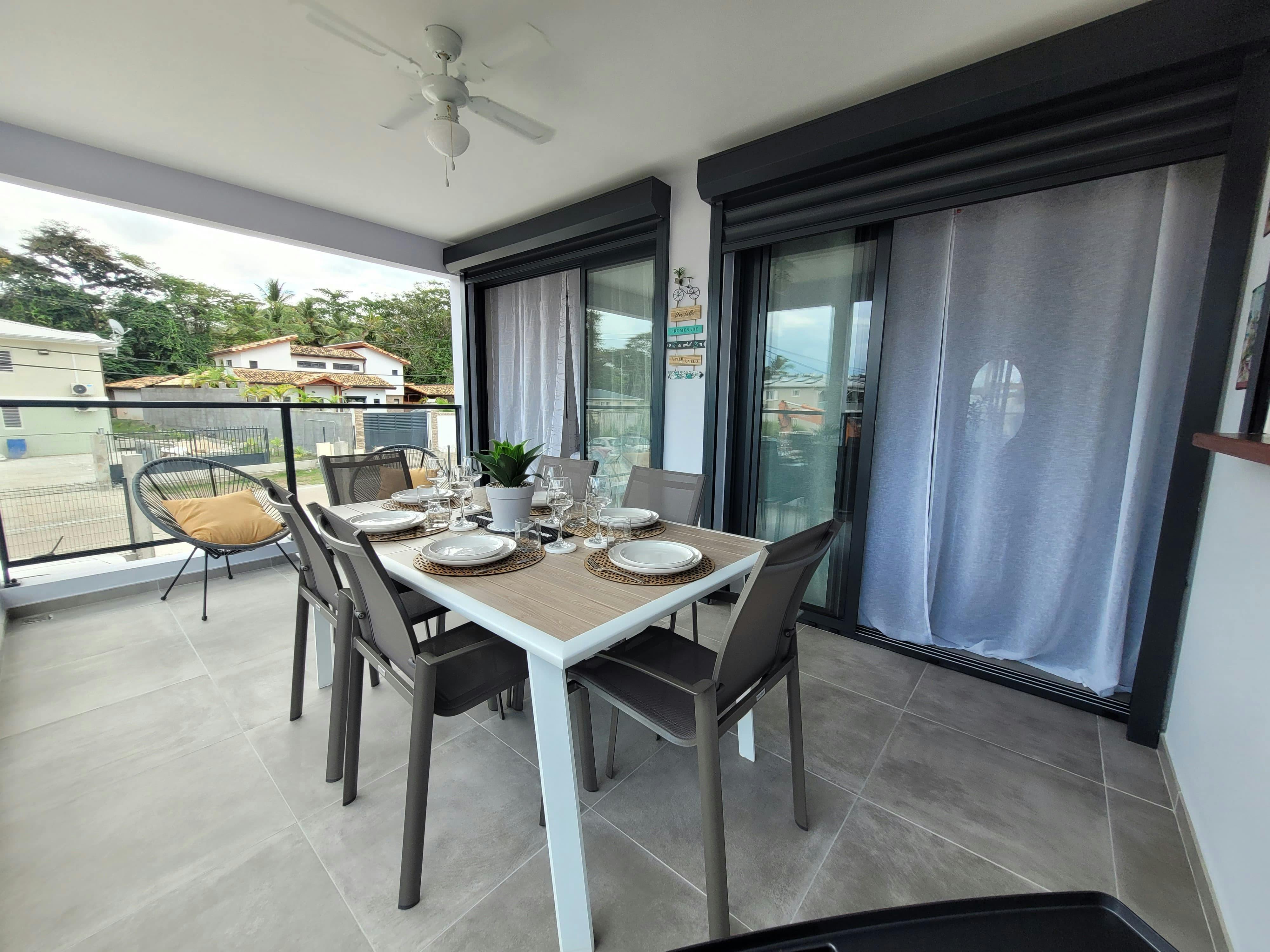 Ambiance détente assurée sur ce balcon de 15 m², avec fauteuils confortables, parfaits pour lire ou profiter d’un café à l’ombre du store banne.