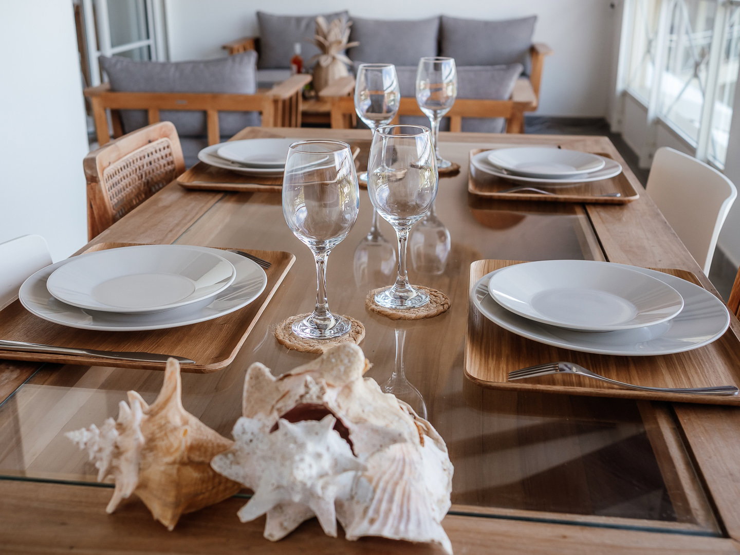 Instant détente sur le balcon : une table soigneusement décorée, assiettes éclatantes et coquillages marins, le tout sublimé par la vue imprenable sur la mer des Caraïbes.