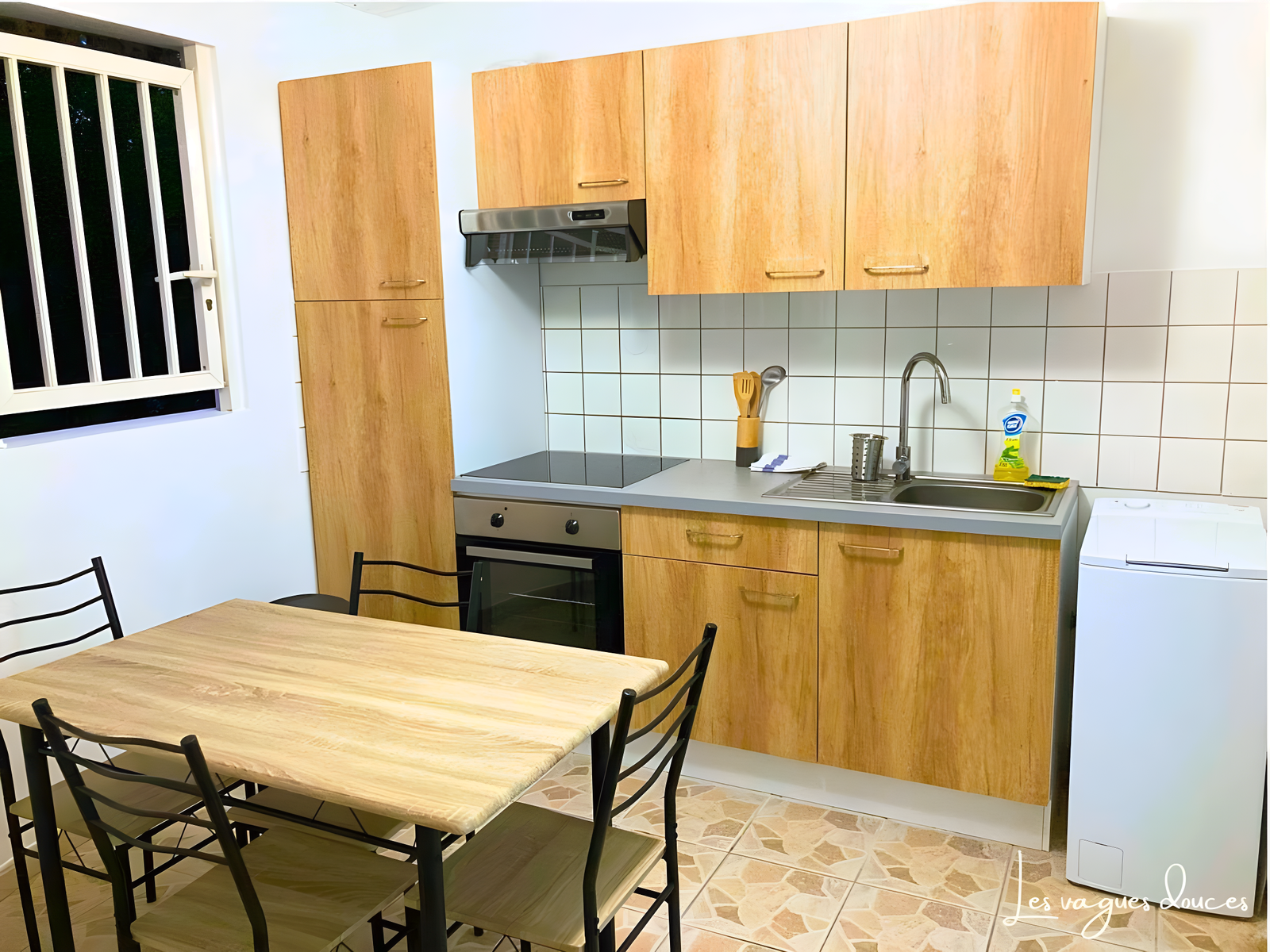 Cuisine moderne et entièrement équipée avec four, plaques de cuisson, micro-ondes, réfrigérateur, et lave-linge. Parfaite pour préparer vos repas dans un espace fonctionnel et accueillant.