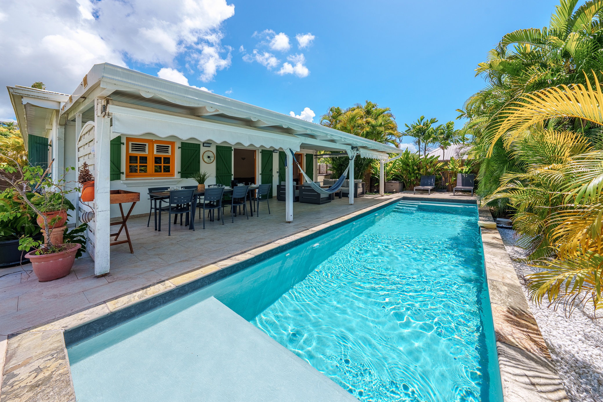 Profitez d'une oasis privée : grande piscine étincelante, terrasse ombragée avec coin repas et hamac pour la sieste. Un cadre tropical paisible et coloré, idéal pour des moments inoubliables en famille ou entre amis.