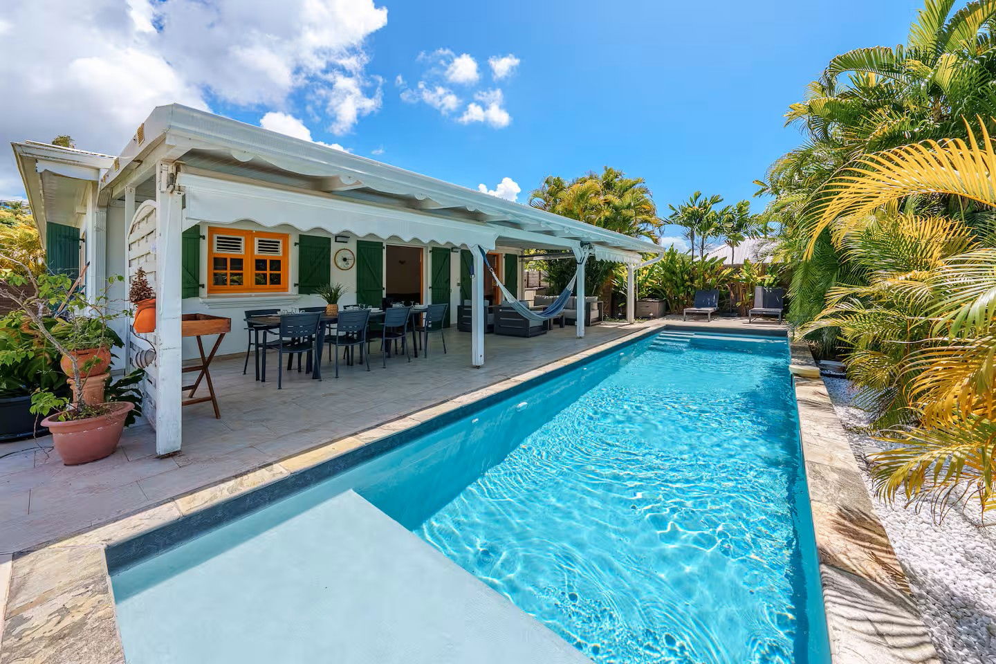Profitez d'une oasis privée : grande piscine étincelante, terrasse ombragée avec coin repas et hamac pour la sieste. Un cadre tropical paisible et coloré, idéal pour des moments inoubliables en famille ou entre amis.