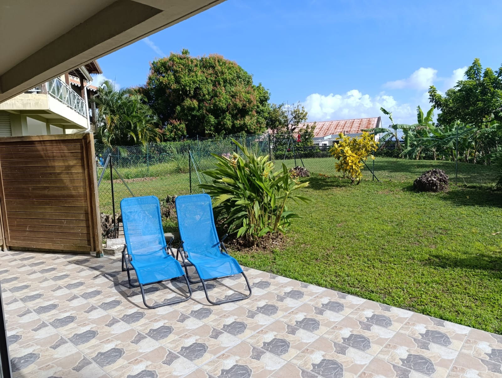Grande terrasse et espace de verdure dans un cadre paisible. Jardin sécurisé avec chaises longues à disposition pour se détendre et profiter pleinement du séjour.