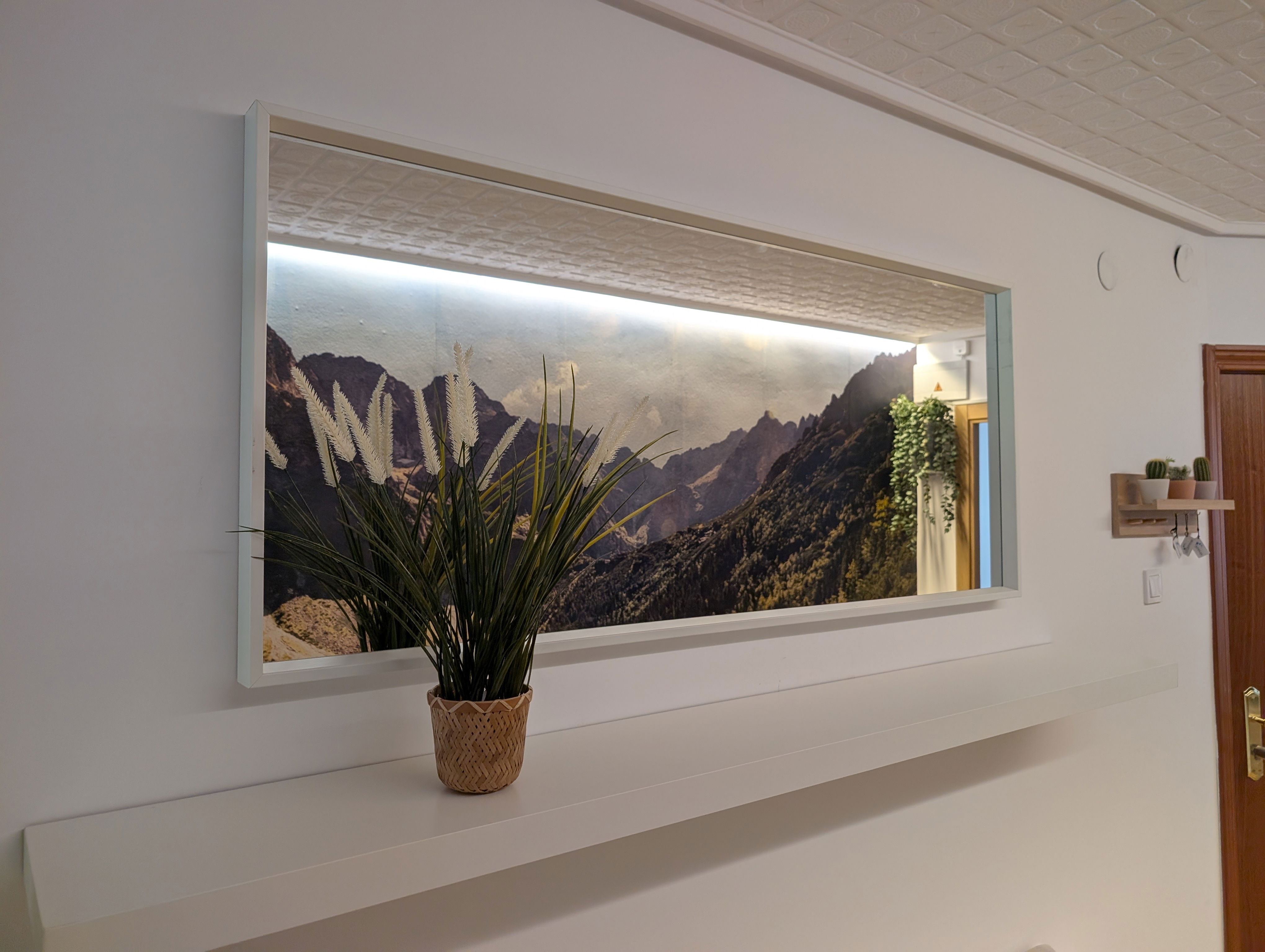 Artistic details and thoughtful decor create a serene ambiance throughout the apartment. This backlit mountainscape adds a unique, calming touch.