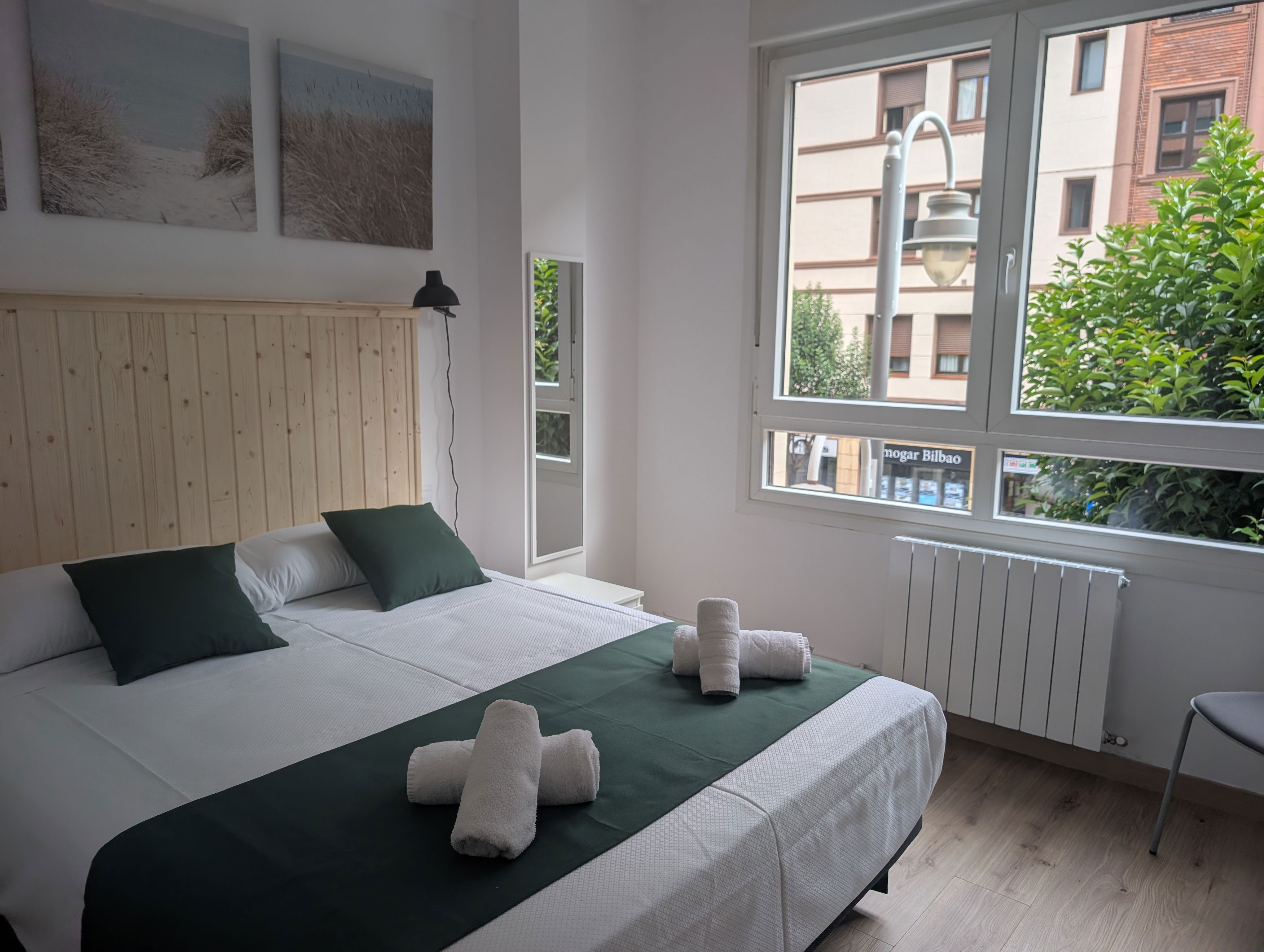 Wake up refreshed in this serene bedroom, where natural light from the large window illuminates the modern, clean design.