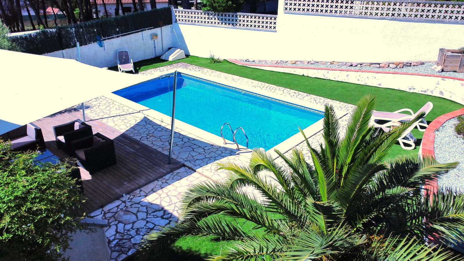 Tauchen Sie ein in den glitzernden Privatpool. Eine schattige Lounge im Freien bietet angenehme Kühle inmitten üppiger Palmen und sonniger Terrassen.