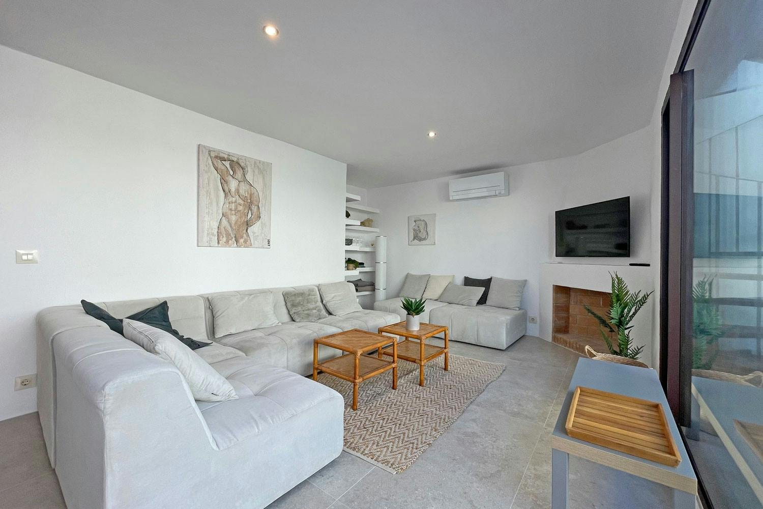 On the third floor, you'll find another living room, perfect for relaxing or entertaining. There's a TV and air conditioning, so you'll be comfortable whatever the weather. Sliding doors lead out to a terrace, where you can sit and enjoy the views.