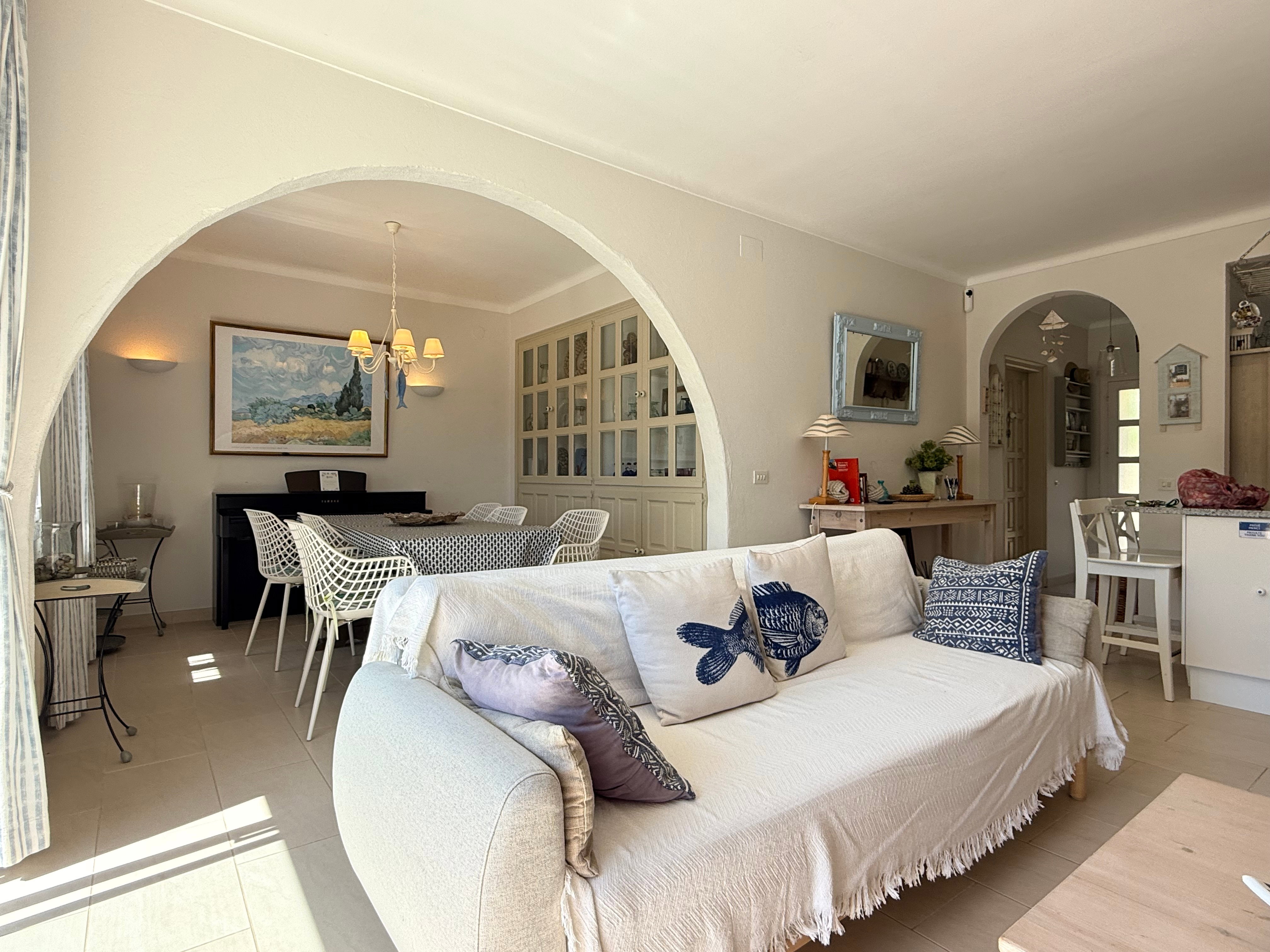Discover bright, inviting interiors with elegant archways. Unwind on the cozy coastal sofa in this family-friendly retreat.