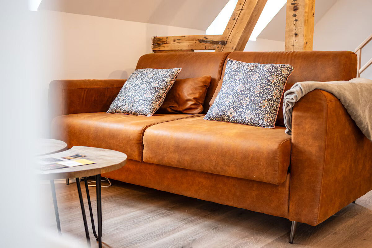 Un canapé douillet avec ses coussins et son plaid bien chaud.