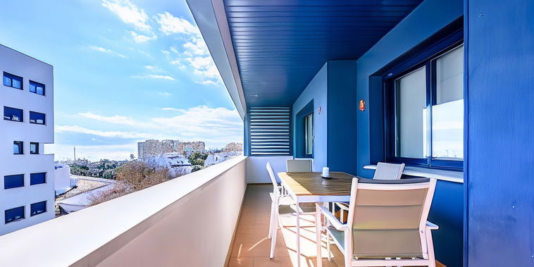 Relax on the sunlit private terrace. Enjoy al fresco dining with vibrant blue accents and open views.