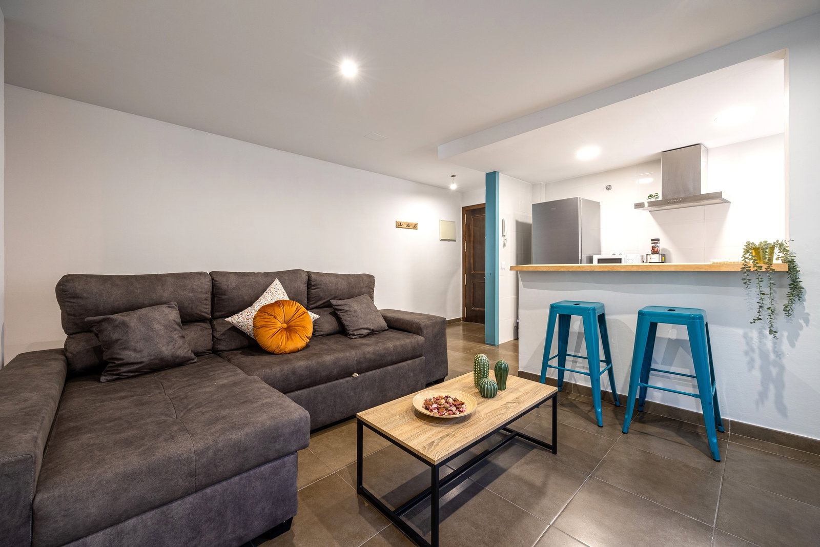 Relax in this modern open-plan living area featuring a plush sectional sofa and a convenient breakfast bar.