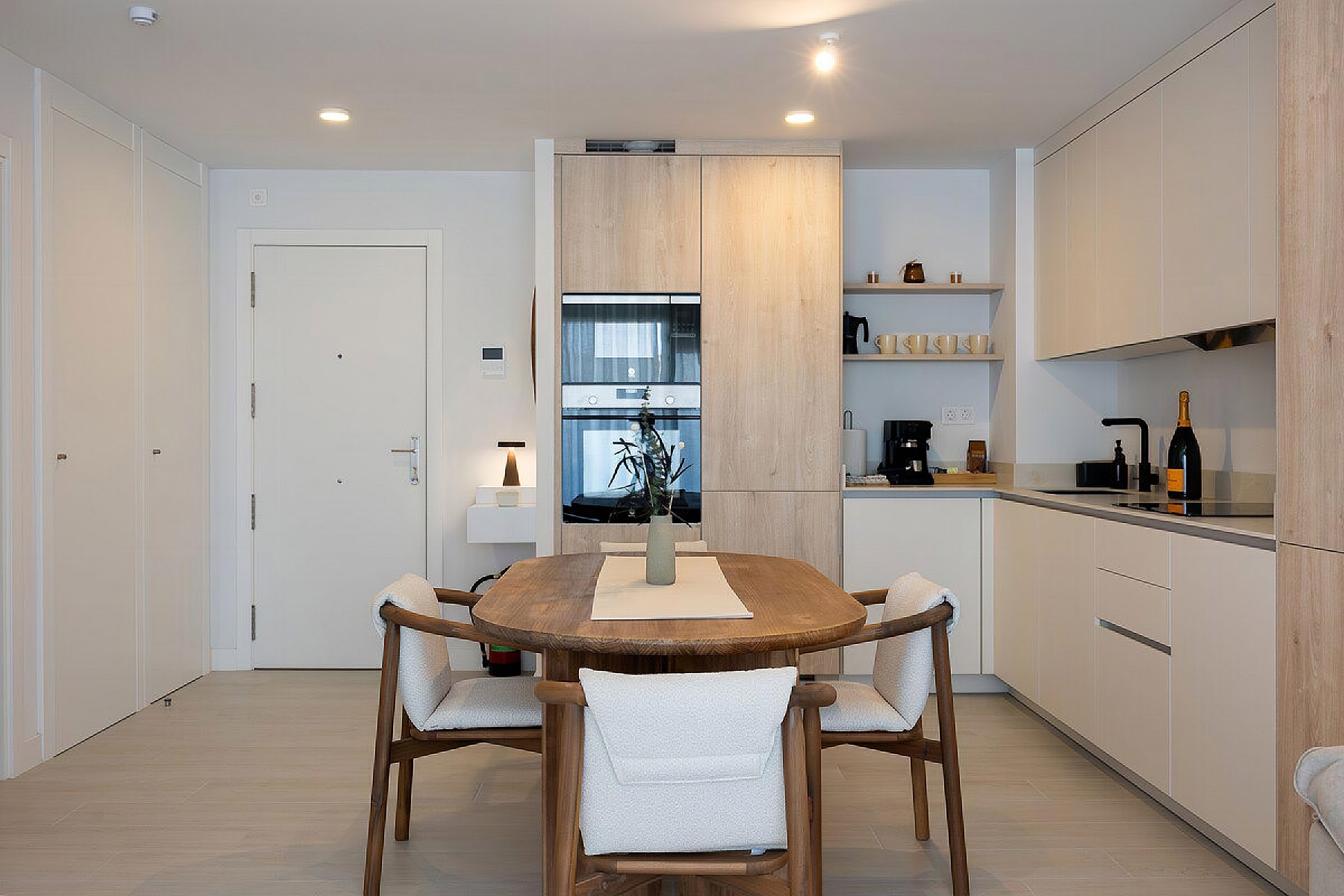 Sleek wooden cabinetry defines this modern open kitchen. An elegant dining table invites guests to enjoy intimate meals.