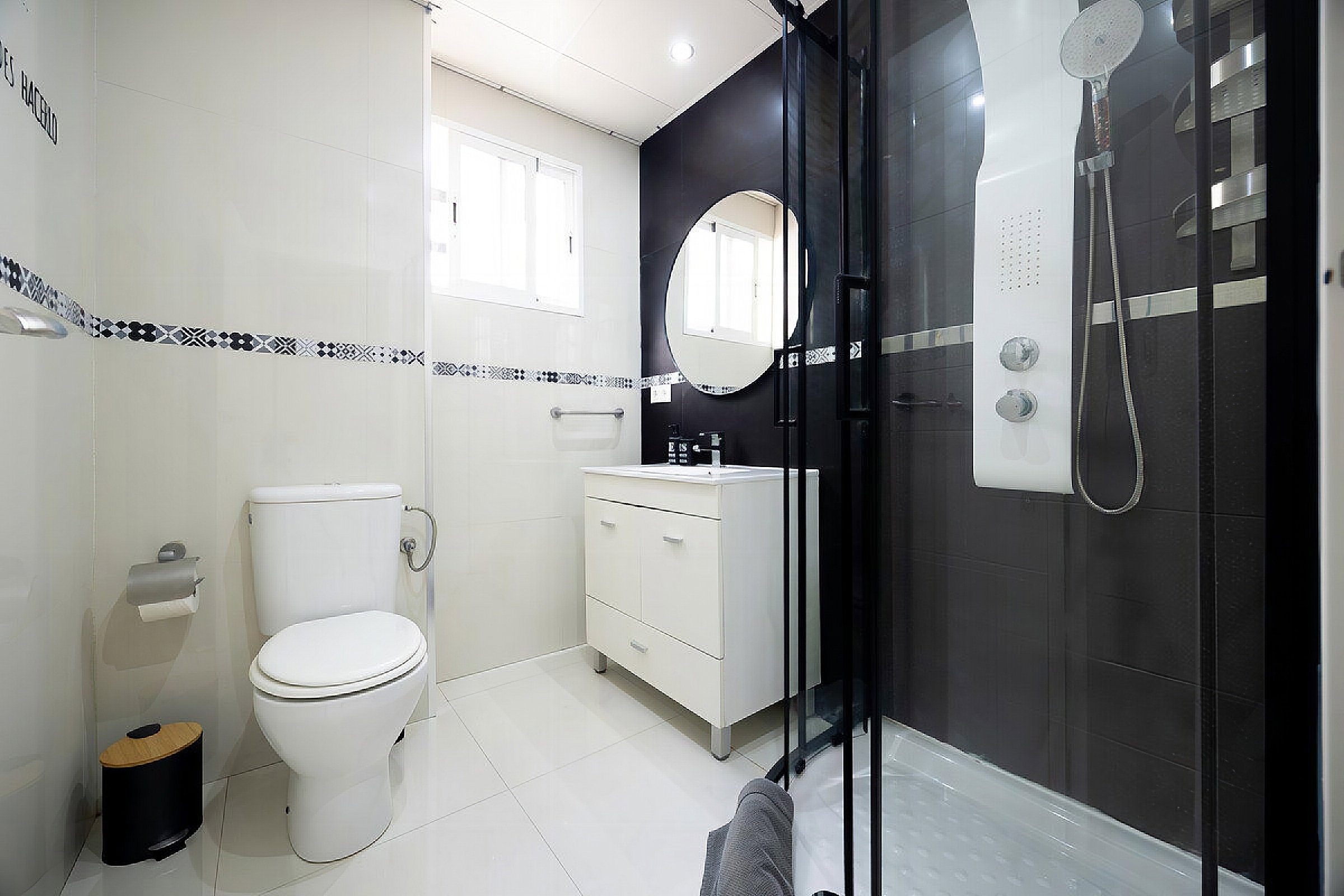 Bright bathroom with a modern shower and clean towels.