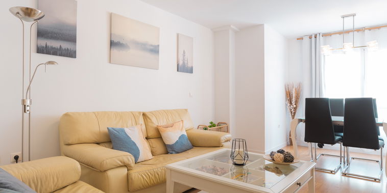 Unwind in the bright living area featuring comfy leather sofas and an inviting dining space filled with natural light.