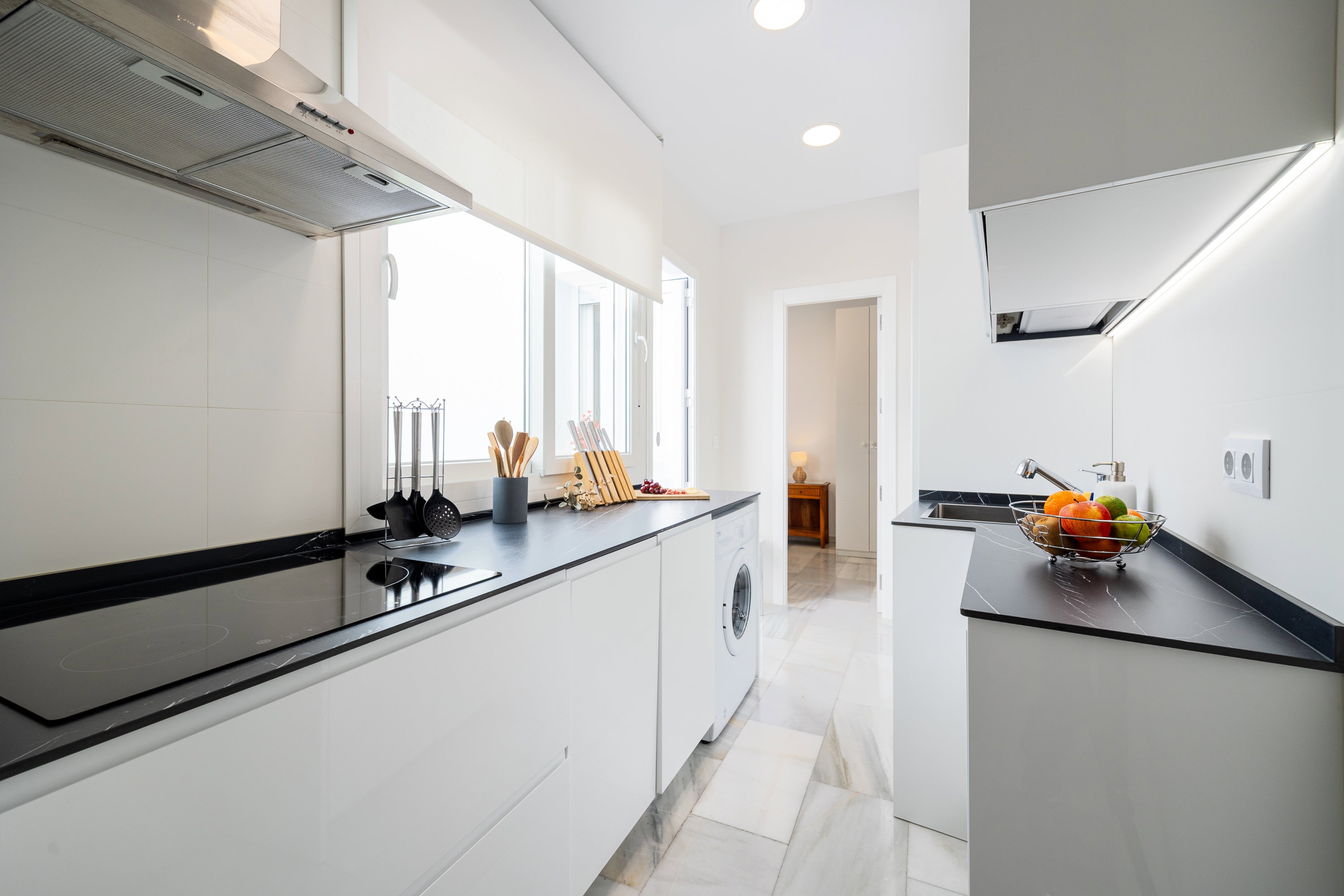 This sleek, modern kitchen offers seamless cabinetry, quality appliances, and abundant natural light.
