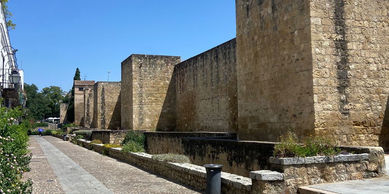 Ancient stone walls line a pristine cobbled pathway. Step outside to experience Cordoba's historical grandeur.
