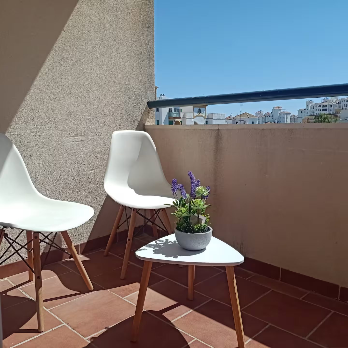 Relax on this sunny private balcony with modern seating and charming town views. Perfect for morning coffee.